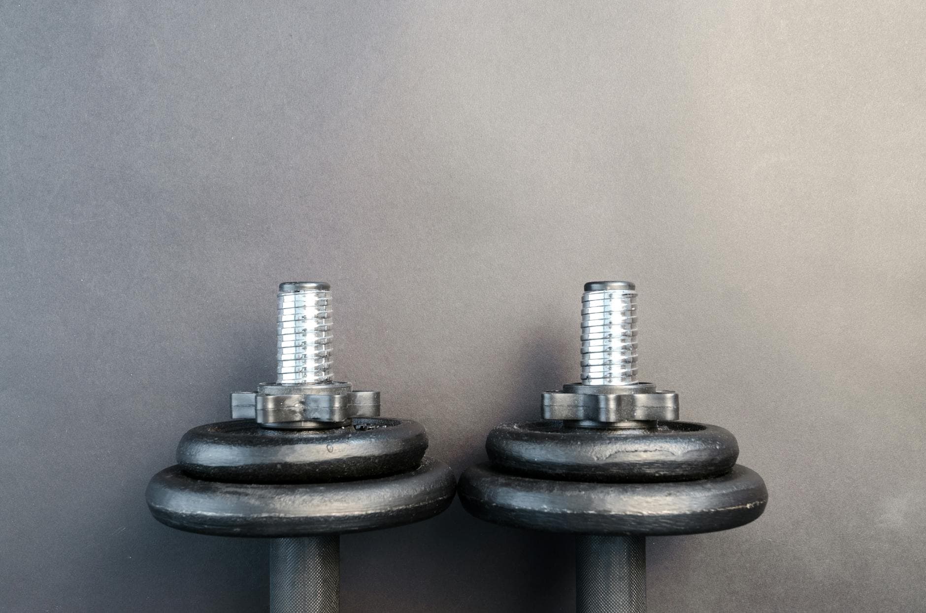 Close-up of two iron dumbbells on a gray background, perfect for strength training images. - dumbbell good morning