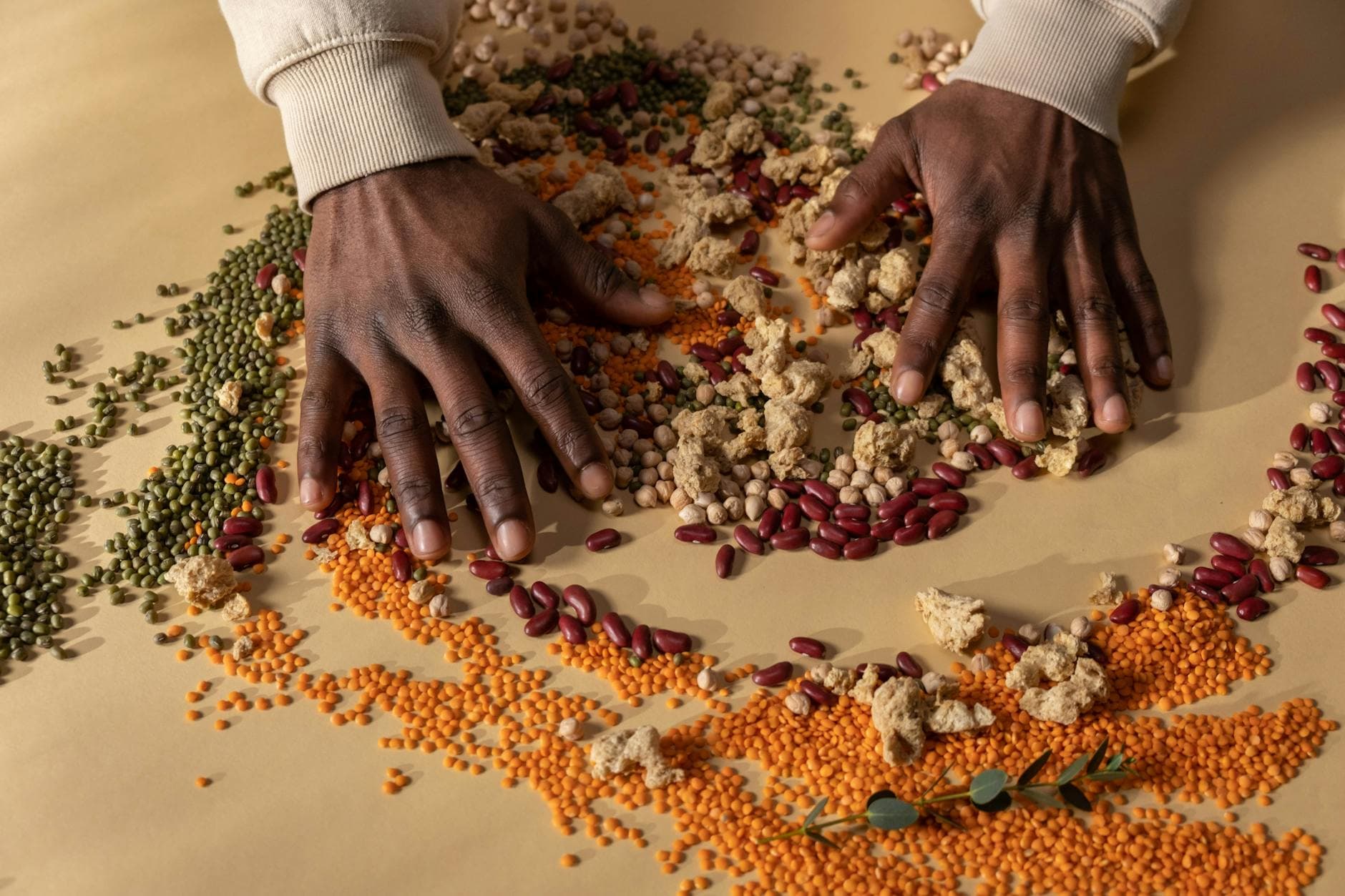 Top view of hands mixing colorful grains and vegan ingredients on a table. - high protein foods