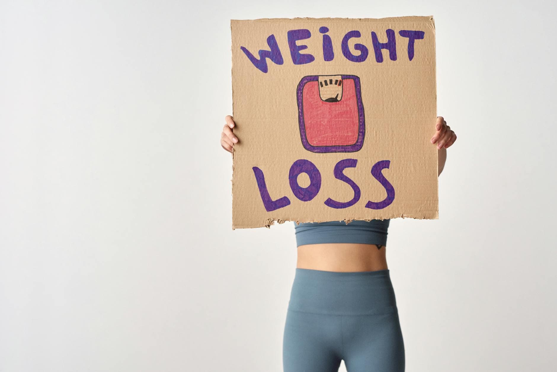 Person holding 'weight loss' sign for fitness motivation and health goals. - reddit weight loss