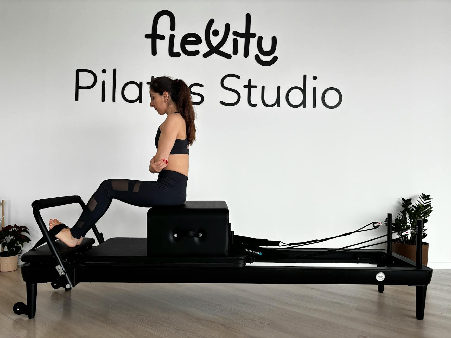 Focused woman practicing on a Pilates reformer in a modern studio. - best pilates exercises