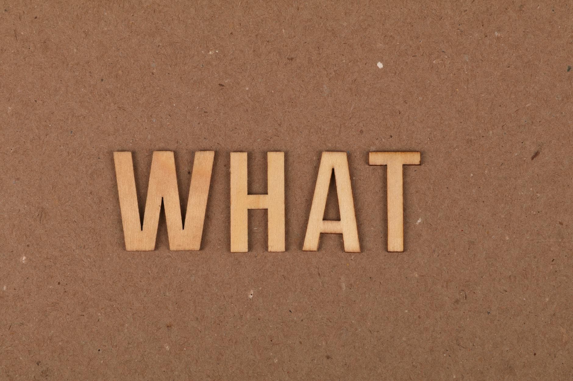 Wooden letters spelling 'What' on a brown cardboard background, close-up view. - what is core
