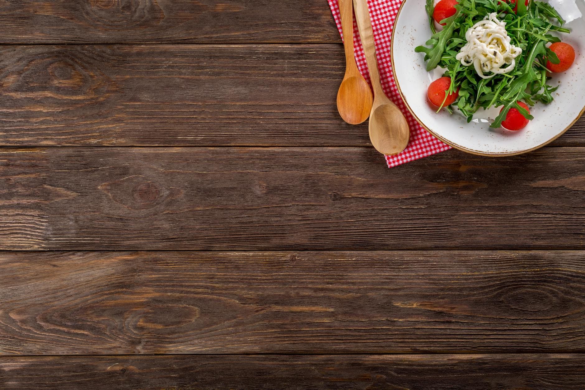 A delicious arugula salad with cherry tomatoes and pasta served on a rustic wooden table with space for text. - healthy dinner for two