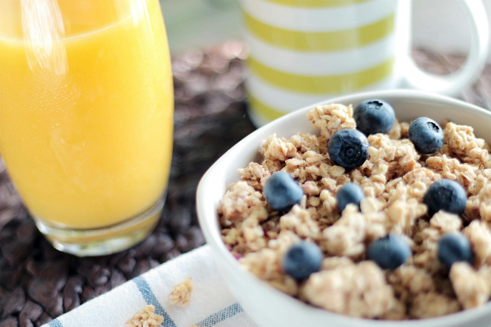 Delicious breakfast bowl with muesli, blueberries, and fresh orange juice, perfect for a healthy start. - healthy fast food breakfast