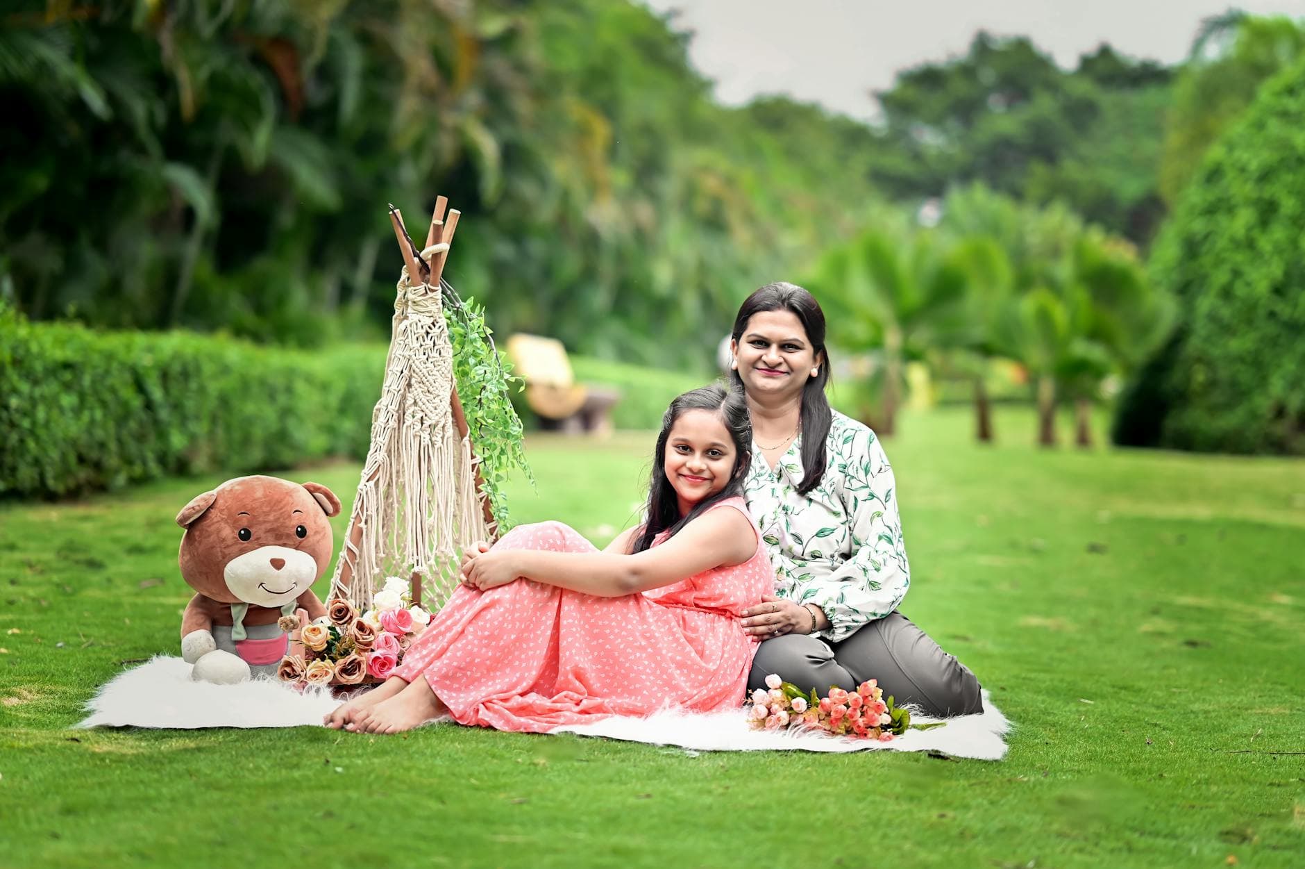 A joyful mother and daughter enjoy a picnic setting in a vibrant green garden. - healthy snacks near me