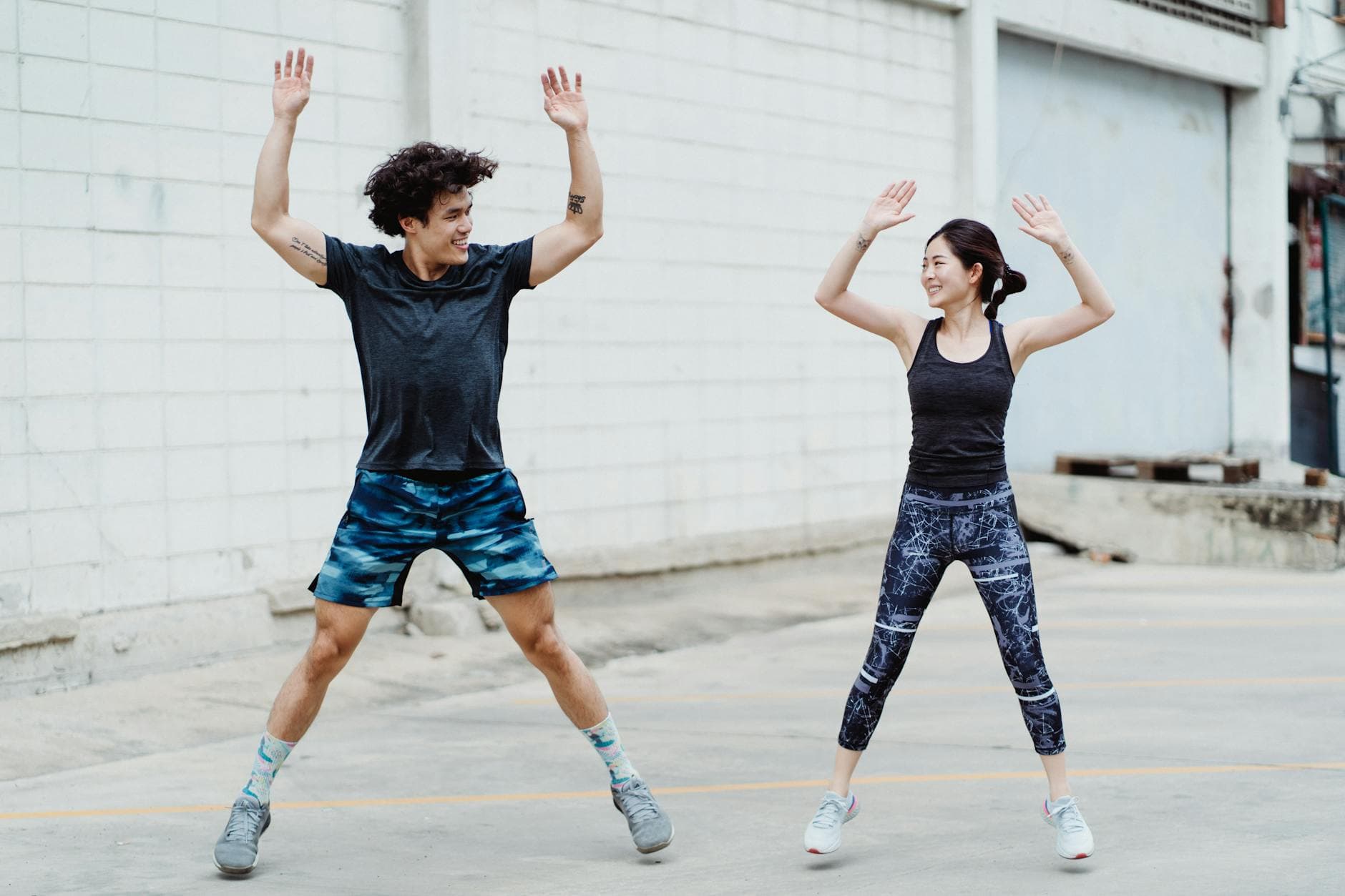 Two young adults exercising outdoors, showcasing energetic fitness and fun. - what is hiit