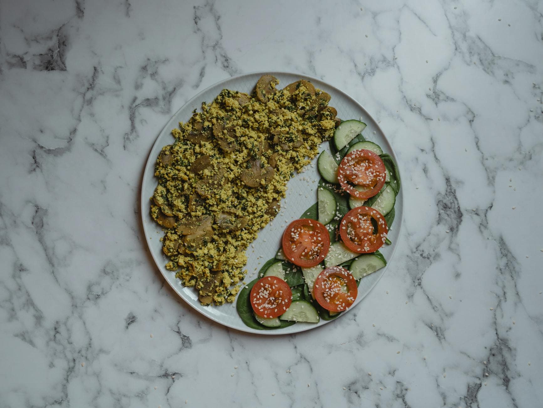 Delicious vegan couscous salad with fresh tomatoes and cucumbers on marble surface. - low carb diet