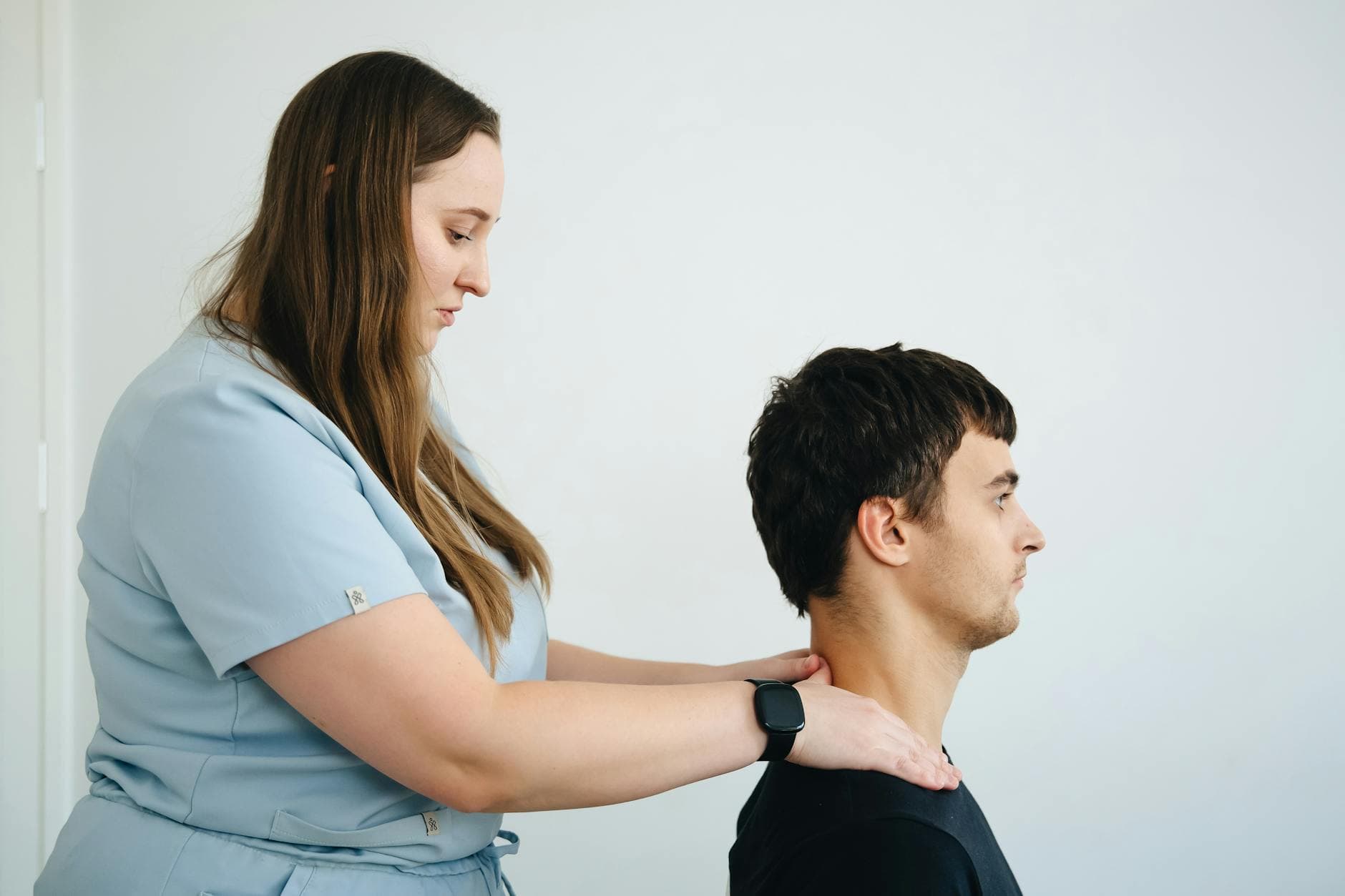 A physiotherapist treating neck pain on a patient in a clinic setting with a focus on healthcare. - back pain relief