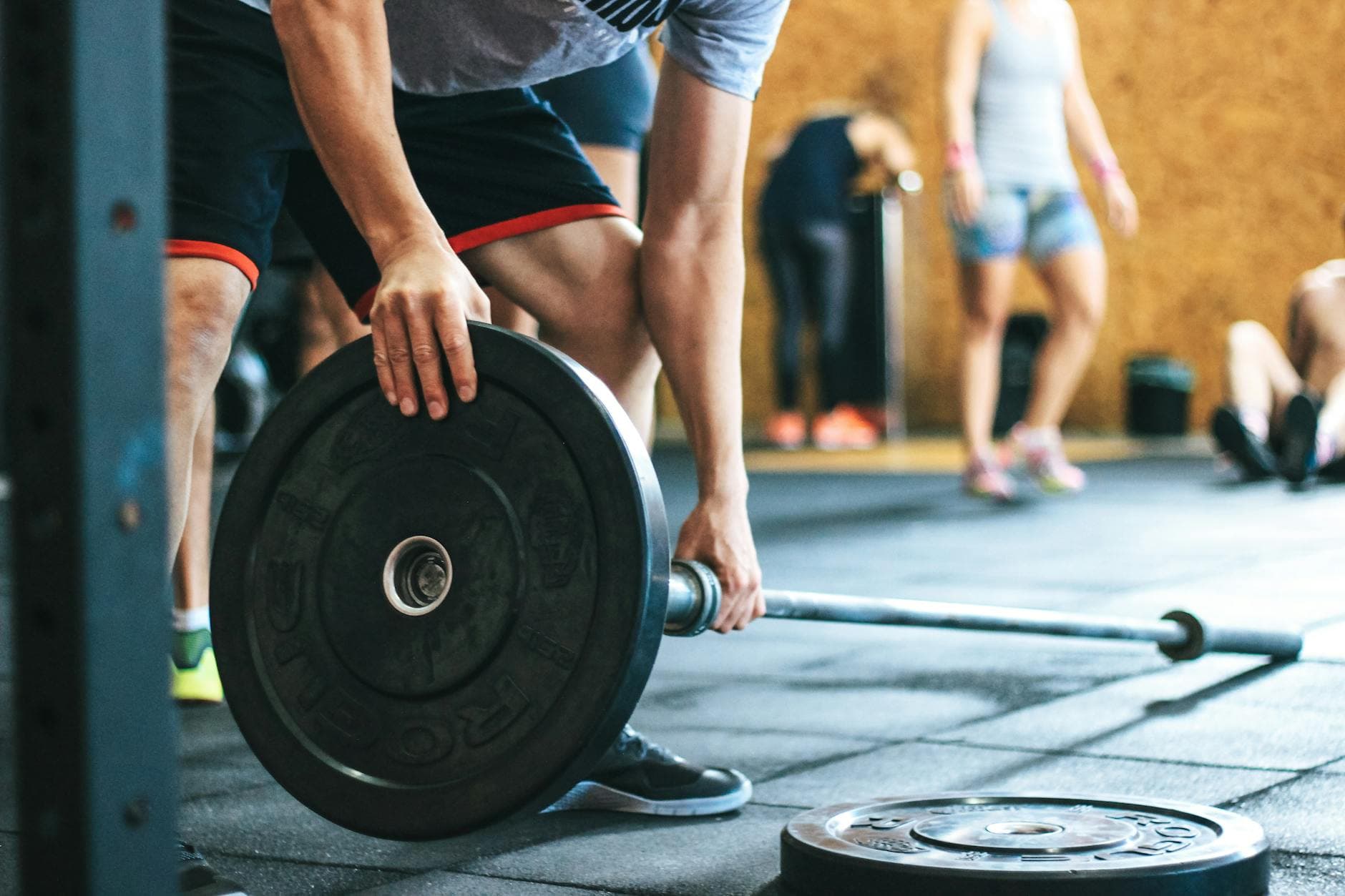 Focused weightlifting session in a gym with diverse athletes participating indoors. - beginner strength training