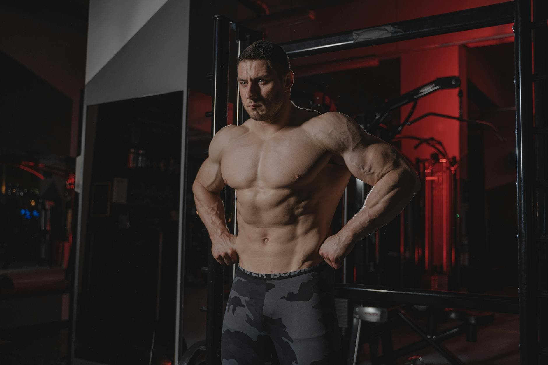 Shirtless bodybuilder flexing muscles under dramatic gym lighting. Fitness and strength. - creatine benefits