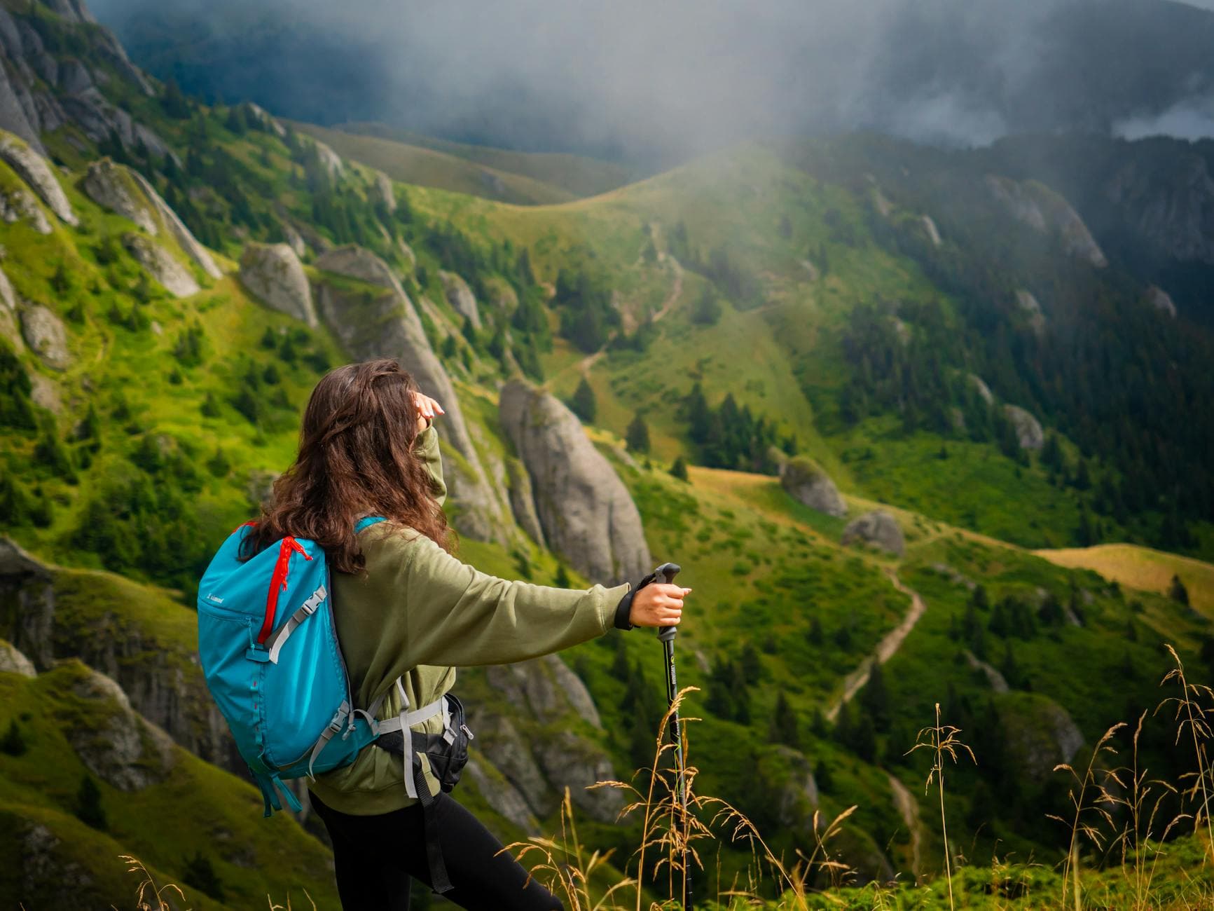 A woman hiker enjoys a breathtaking mountain view in Romania, perfect for adventure and travel photography. - hiking energy snacks