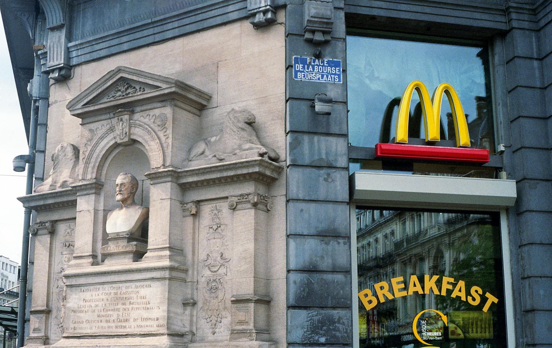 A historic building corner in Brussels featuring a McDonald's sign and a classical sculpture. - healthiest mcdonald's breakfast