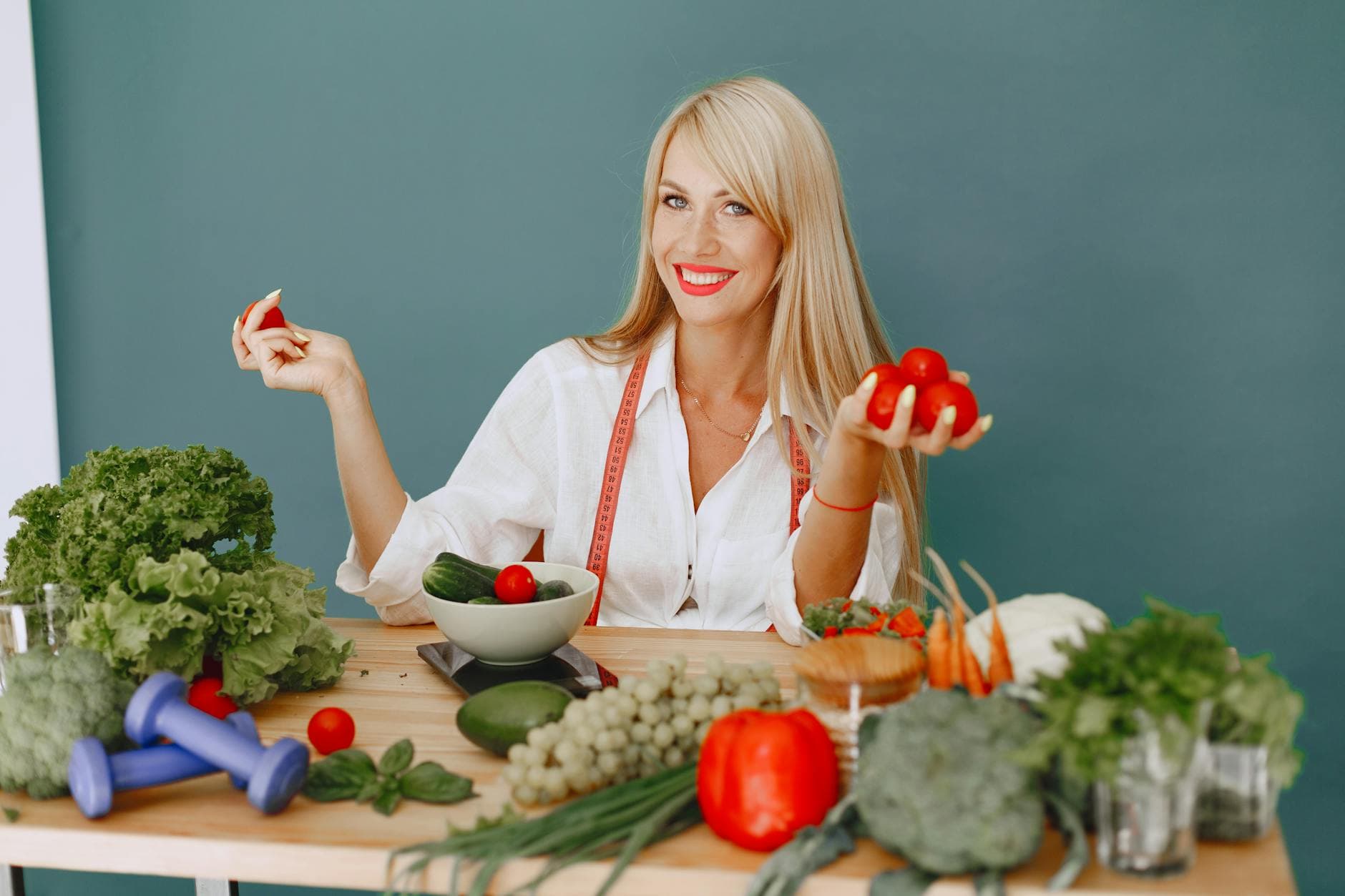 Healthy lifestyle concept with woman holding tomatoes and surrounded by fresh vegetables in a studio setting. - optimal nutrition guide