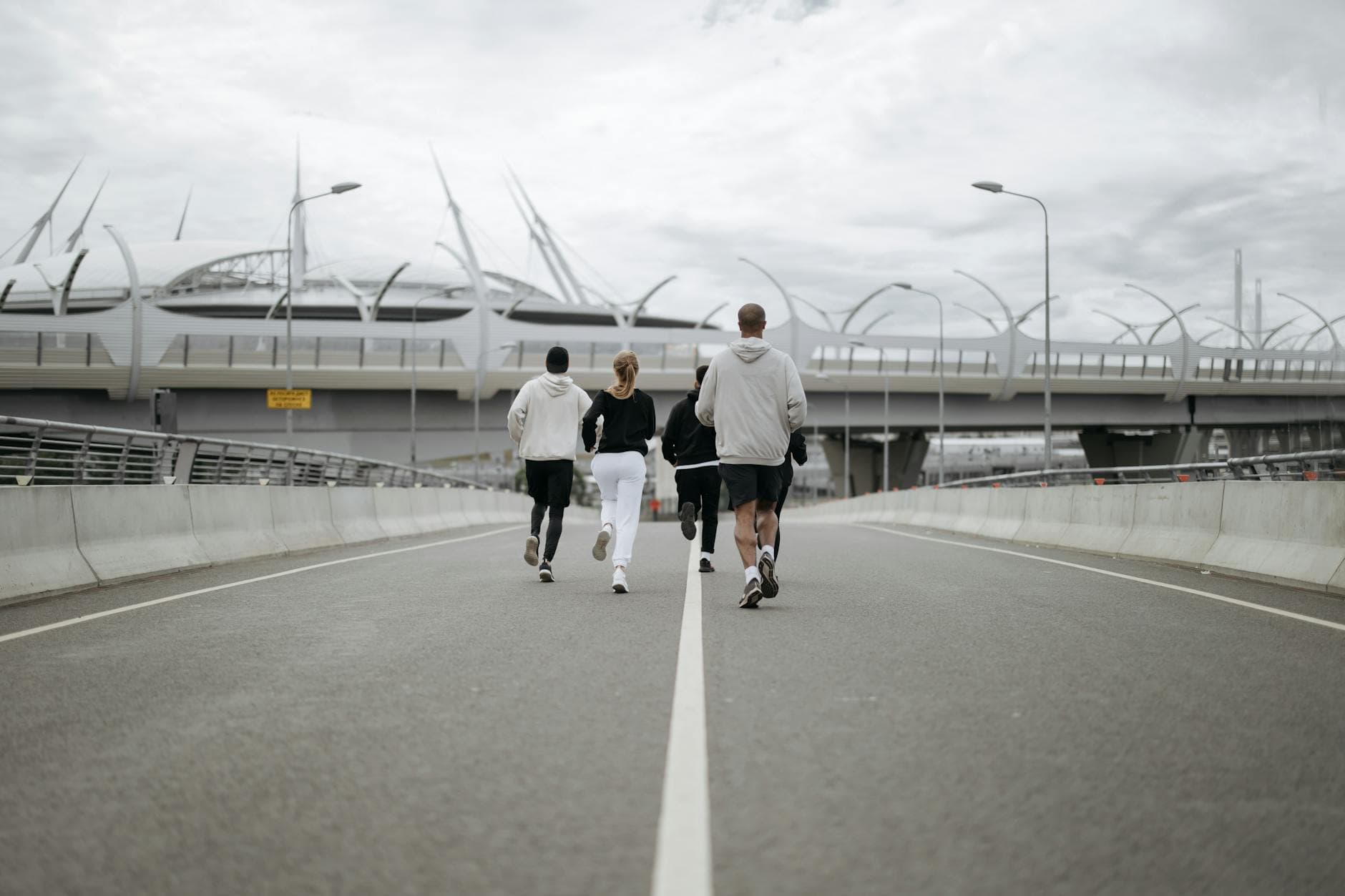 Diverse group jogging on a modern bridge in sportswear, promoting health. - running plan for beginners