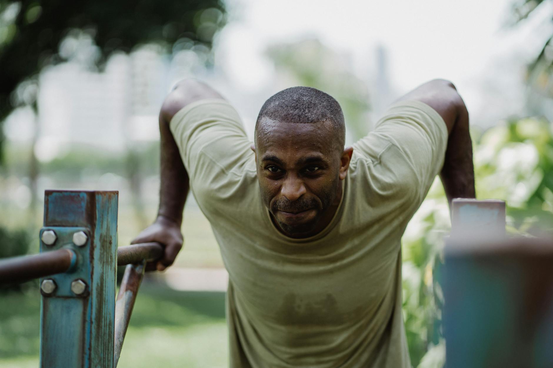 Focused athlete exercising on parallel bars outdoors, showing determination and strength. - best cardio exercises