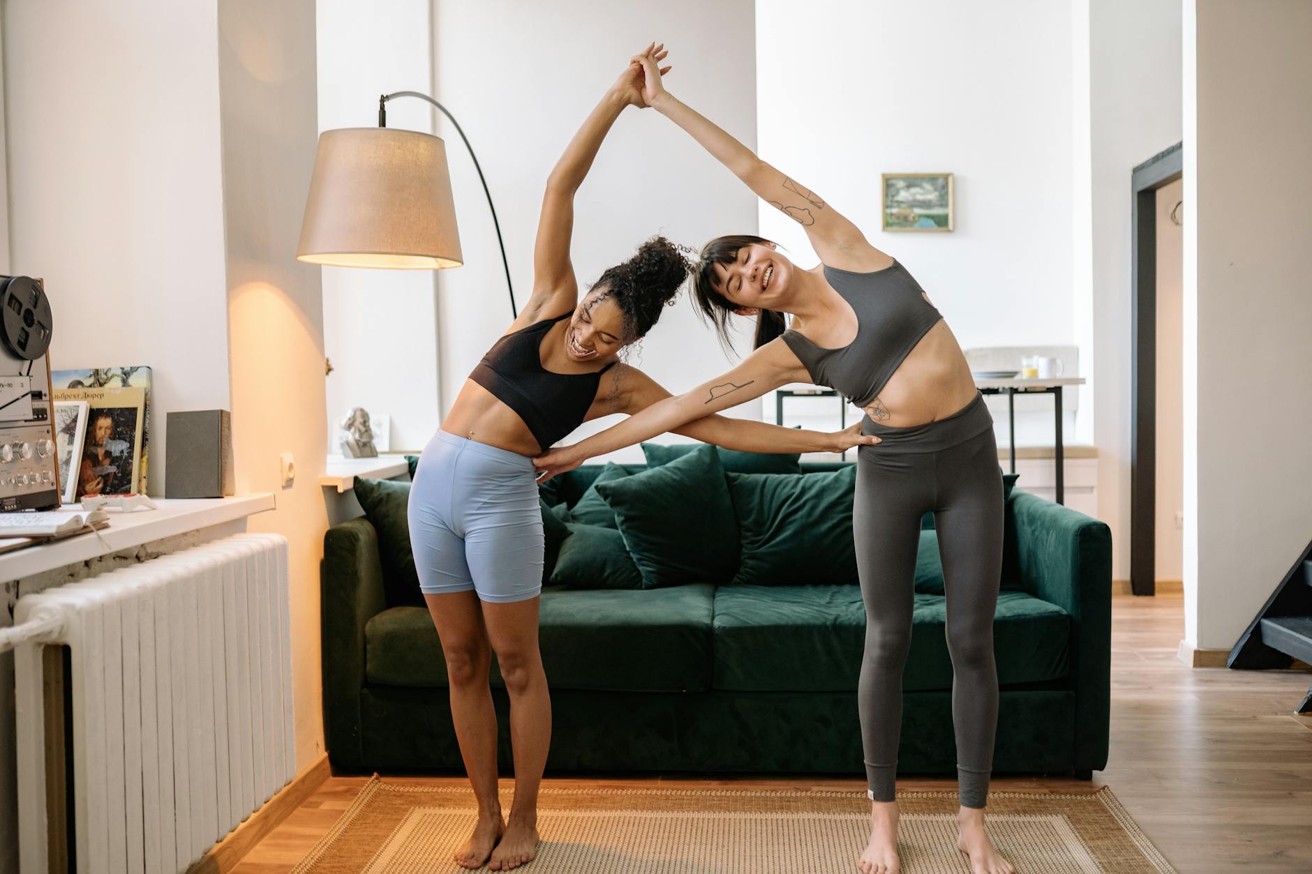 Two women practicing yoga in a modern living room, enjoying a healthy lifestyle. - best flexibility exercises