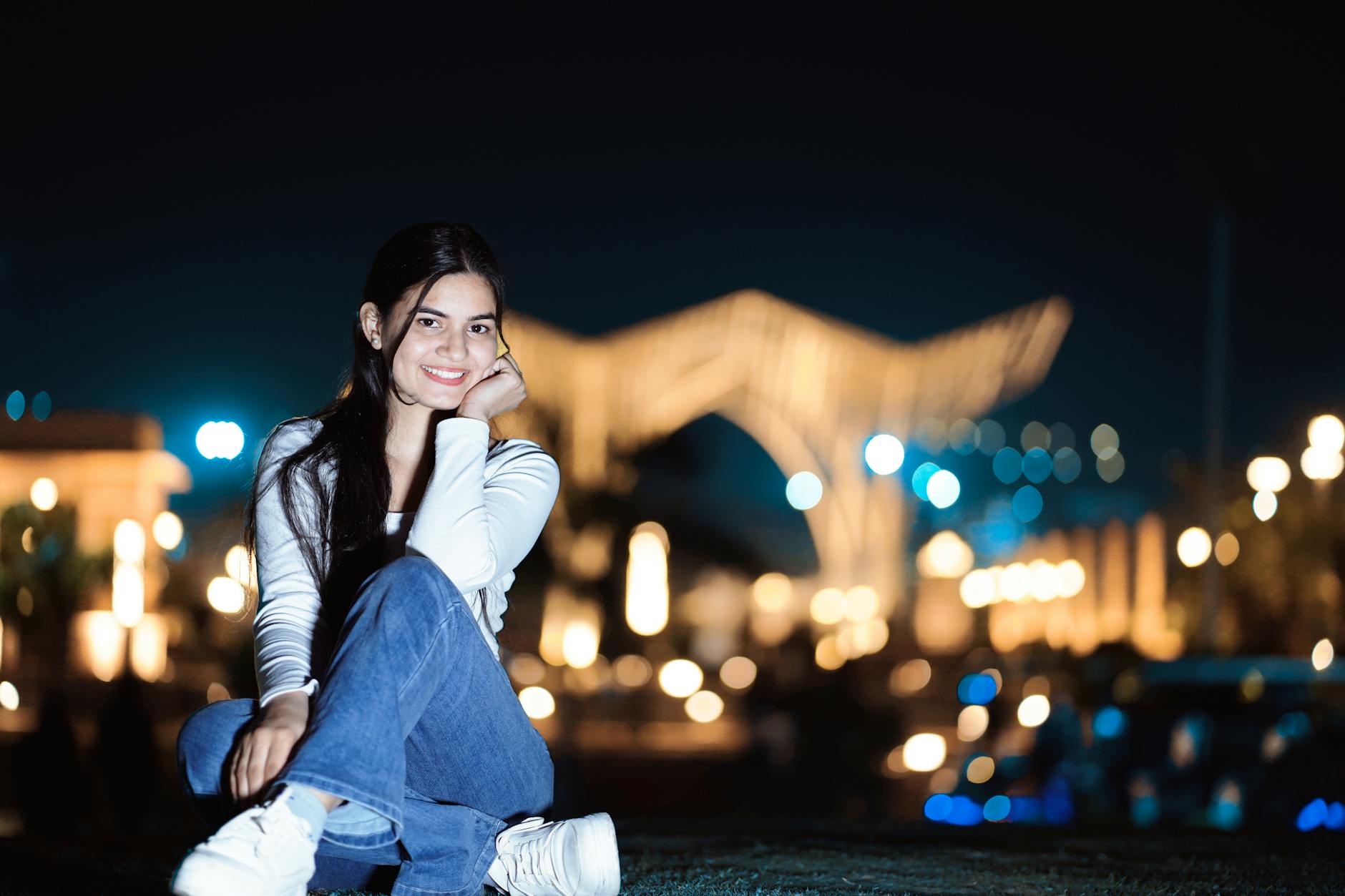 Portrait of a young woman smiling outdoors at night with city lights in the background. - how to fix bad posture