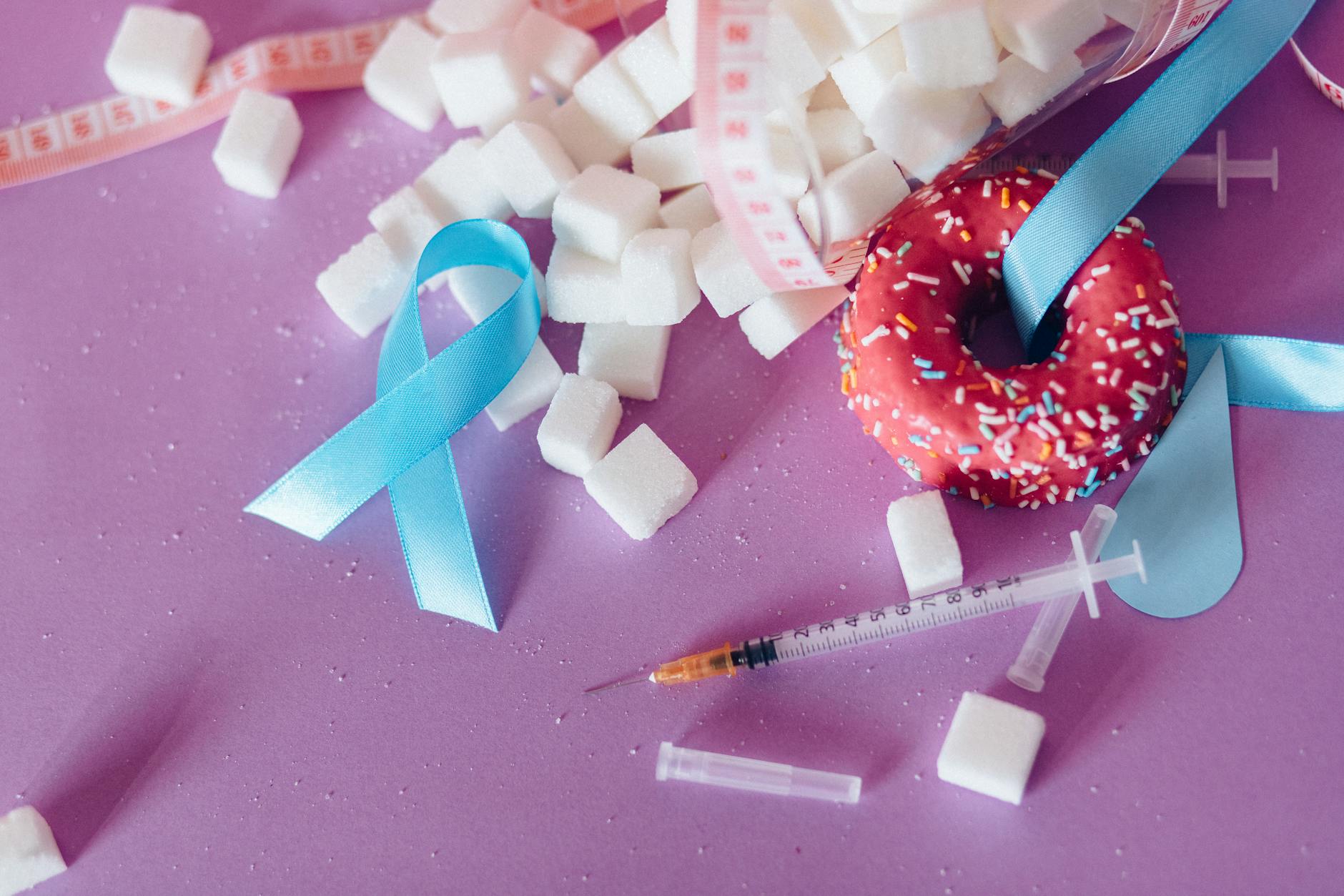 Creative composition highlighting diabetes awareness with donut, syringe, and sugar cubes on purple background. - foods that cause inflammation
