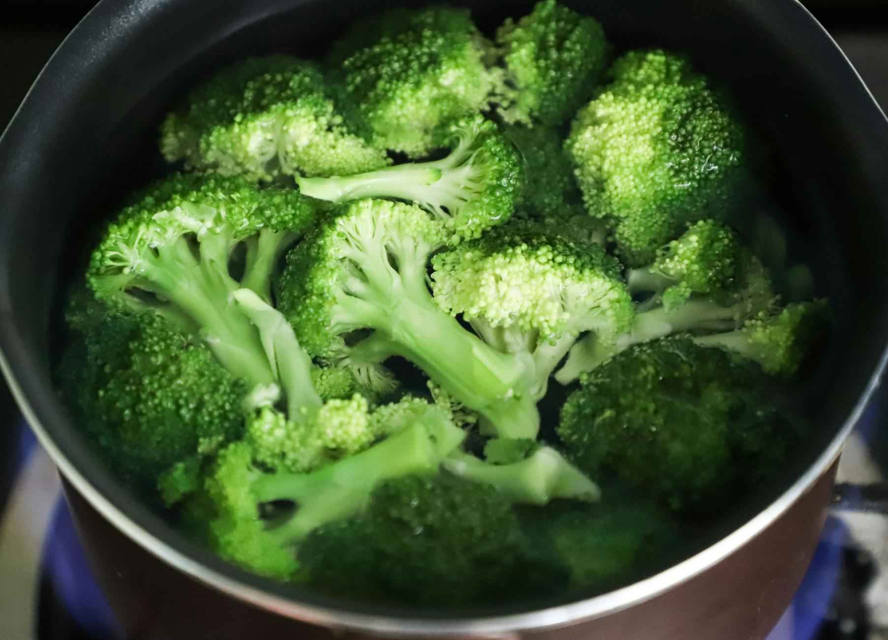 Bright green broccoli florets boiling in a pot for a fresh, healthy meal. - free keto recipes