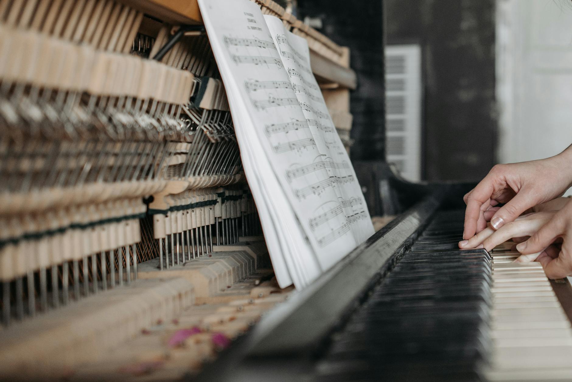 Close-up of hands playing piano keys with open sheet music, emphasizing learning and teaching. - guided meditation for beginners