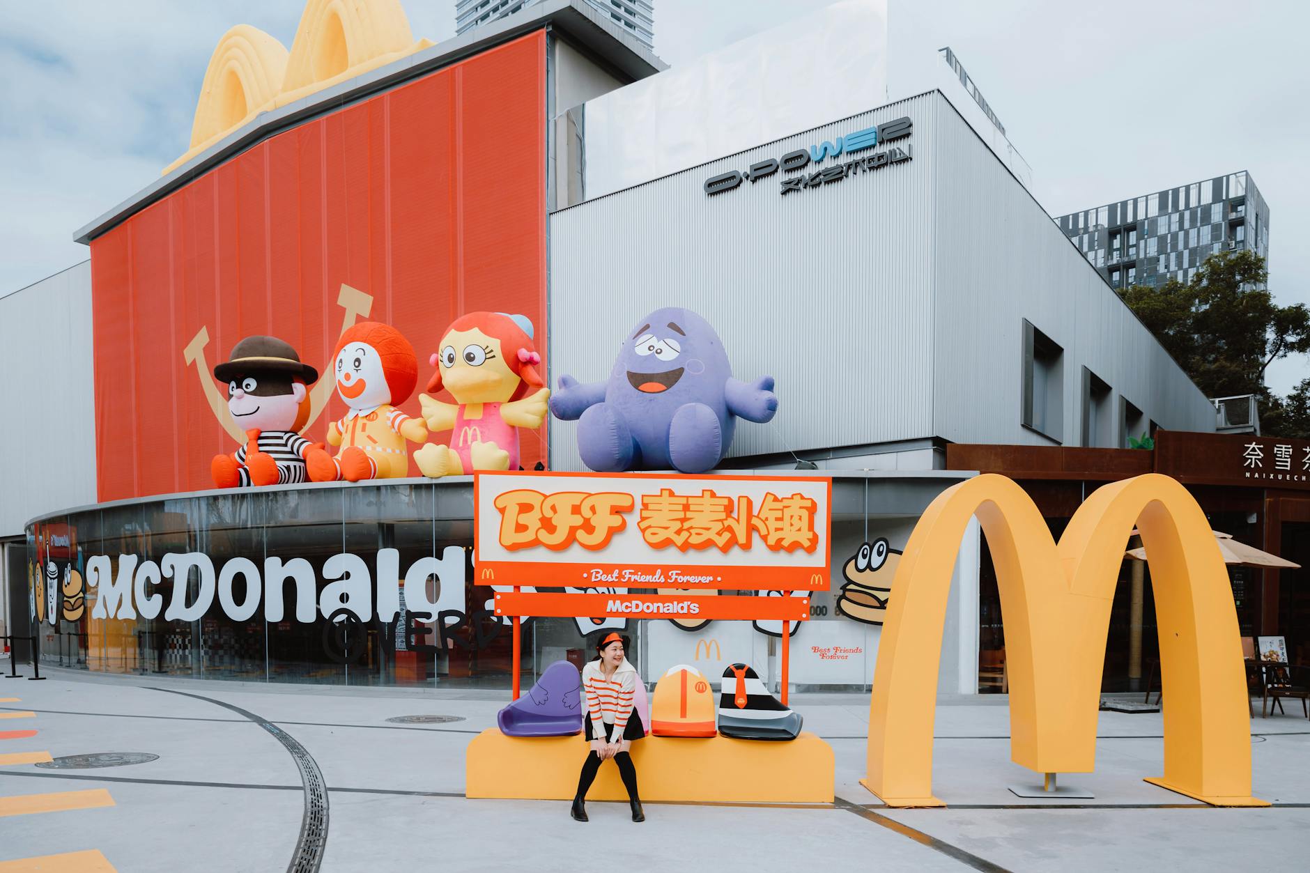 Outdoor view of a McDonald's with large character statues and seating area. - healthiest mcdonald's breakfast