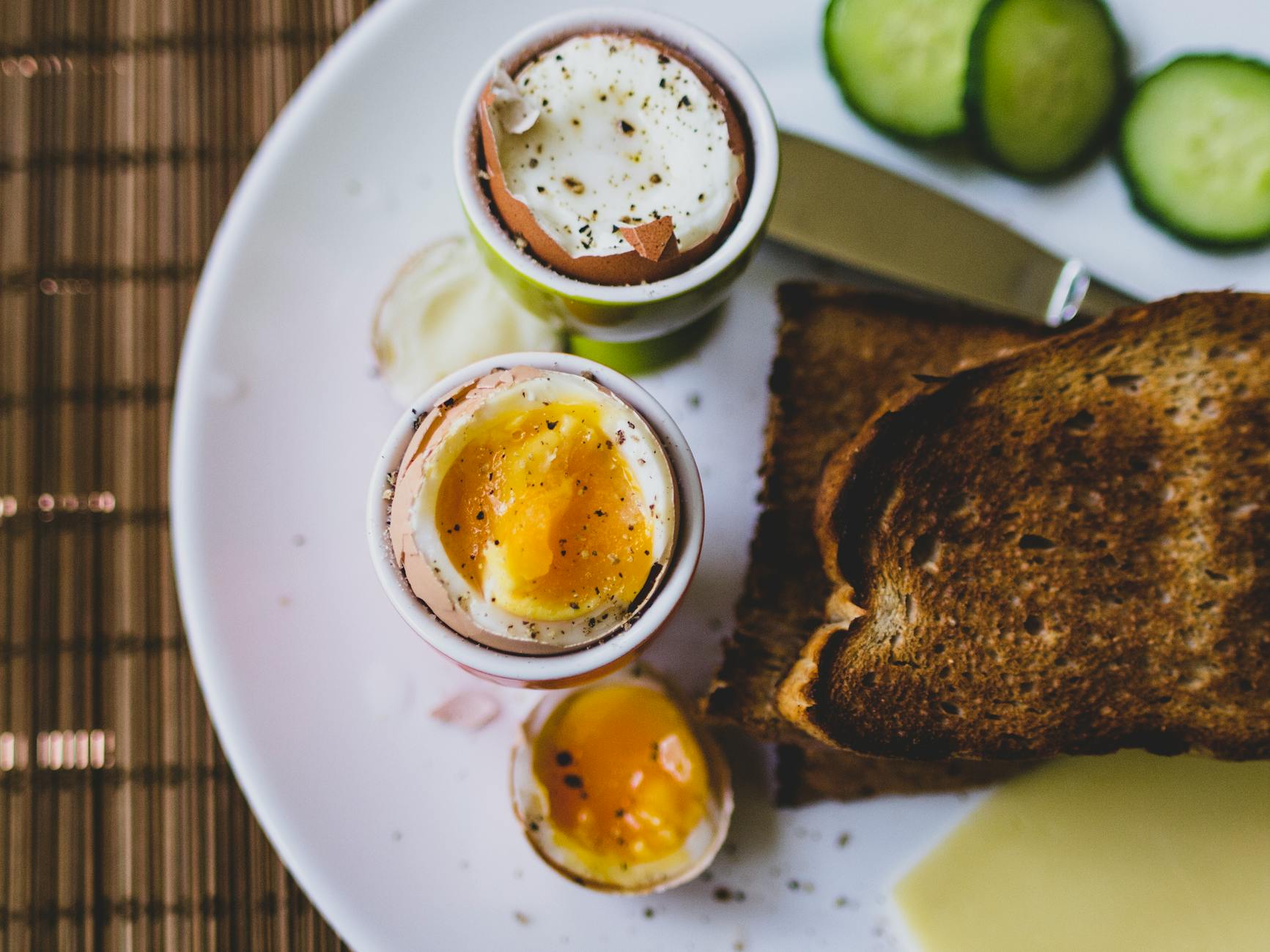 Top view of a breakfast plate featuring soft boiled eggs and toast, ideal for a nutritious meal. - healthy breakfast eggs