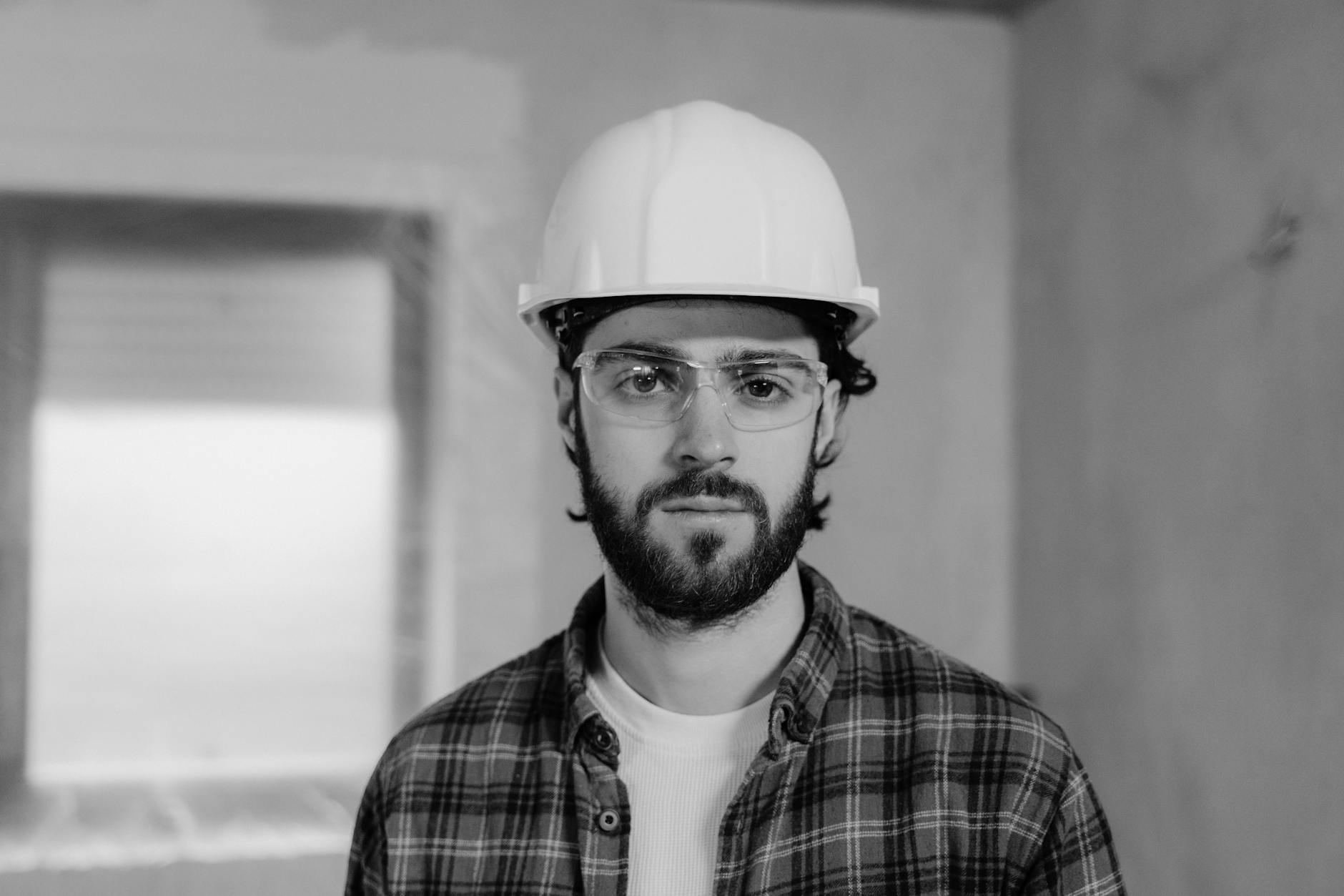 A focused construction worker wearing a hard hat stands indoors, ready for work. - improve gut health
