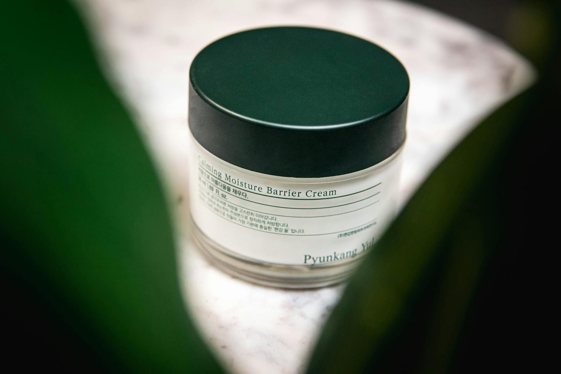 Close-up of Pyunkang Yul Calming Moisture Barrier Cream displayed on a marble surface. - just natural skincare reviews