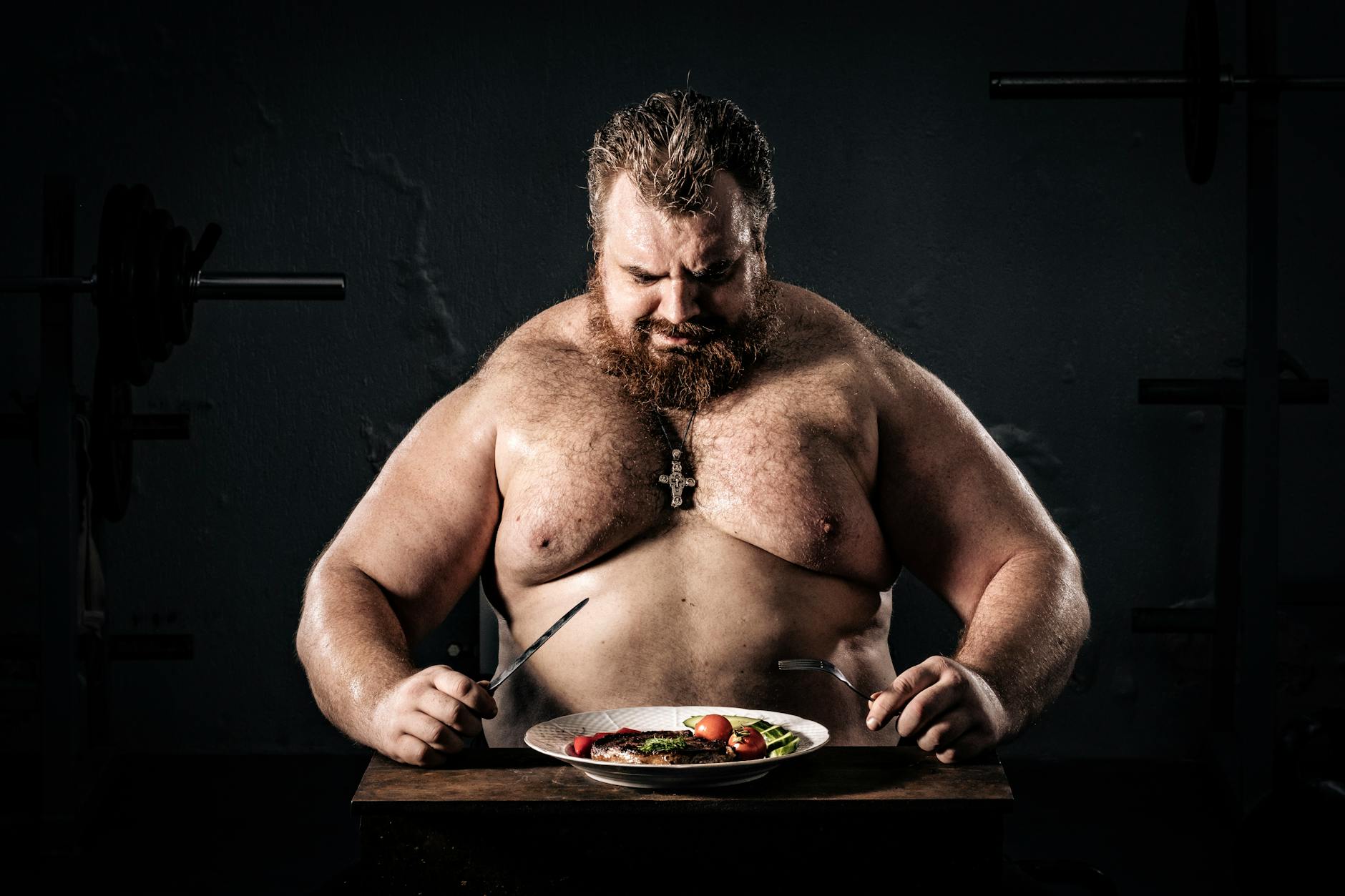 Shirtless muscular man eating a nutritious meal, symbolizing strength and health. - protein foods for weight loss
