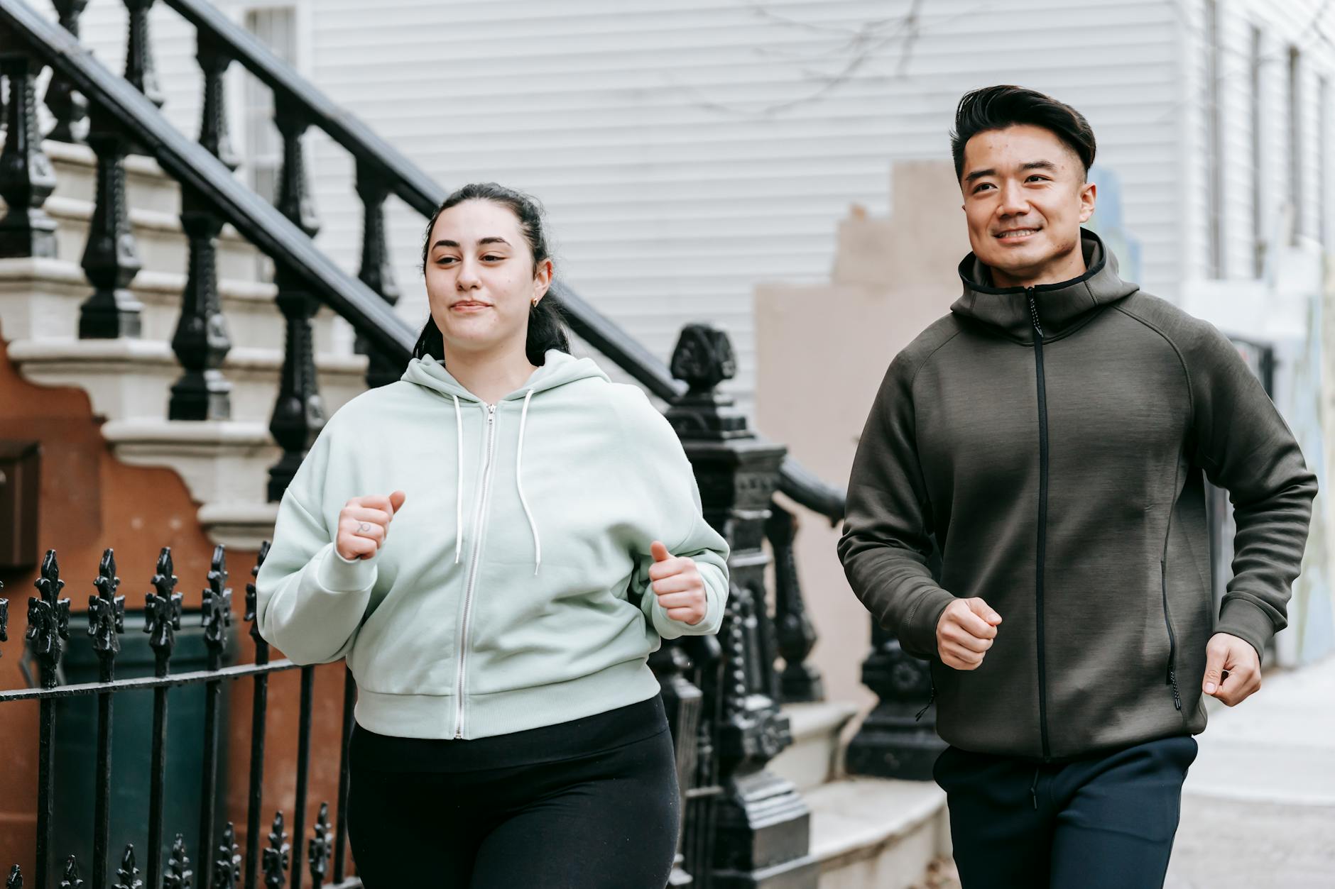 Two adults jogging in urban setting, promoting fitness and wellness outdoors. - running for weight loss