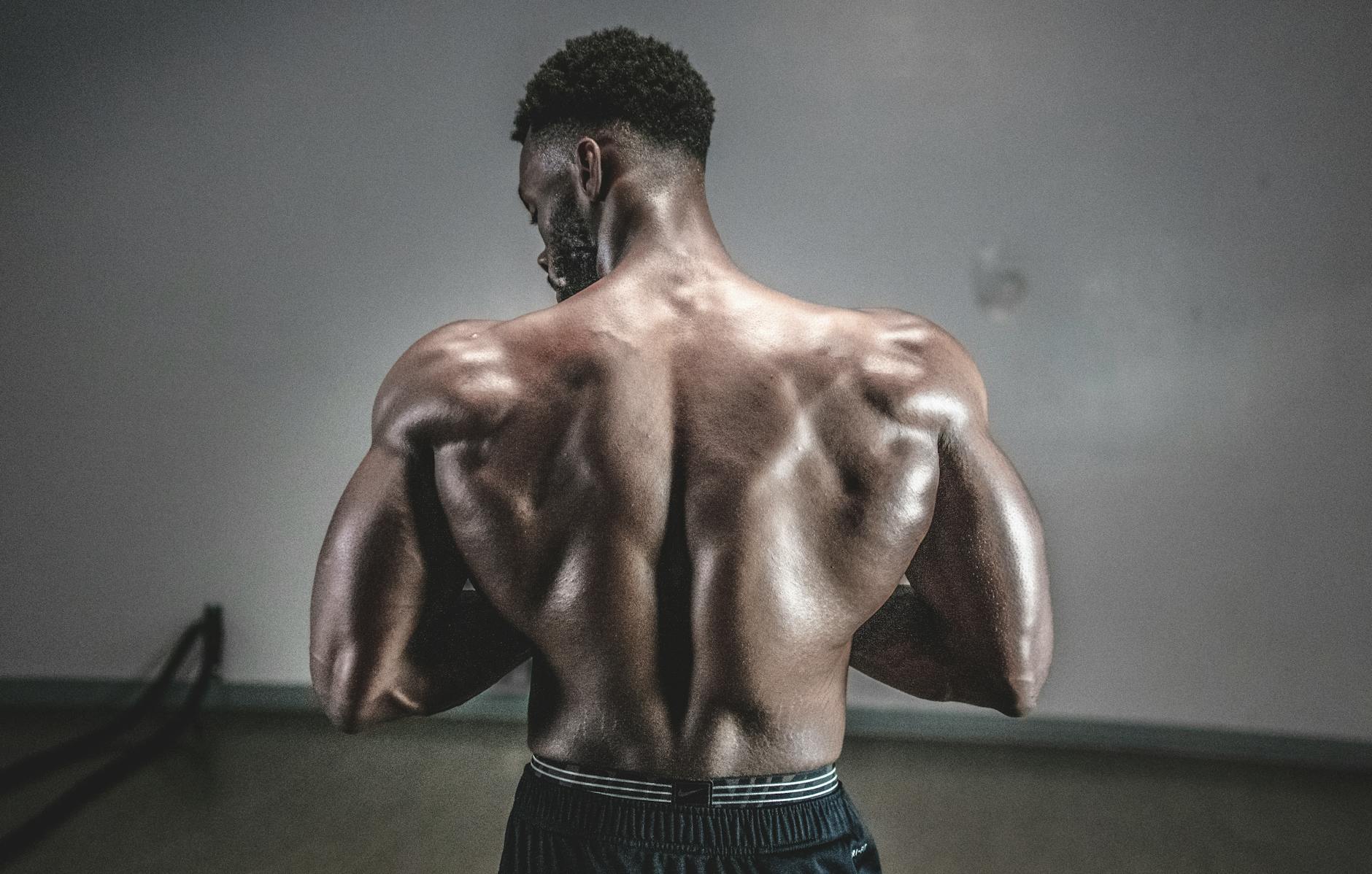 A shirtless man displaying his muscular back, showcasing strength and fitness. - upper back posture exercises