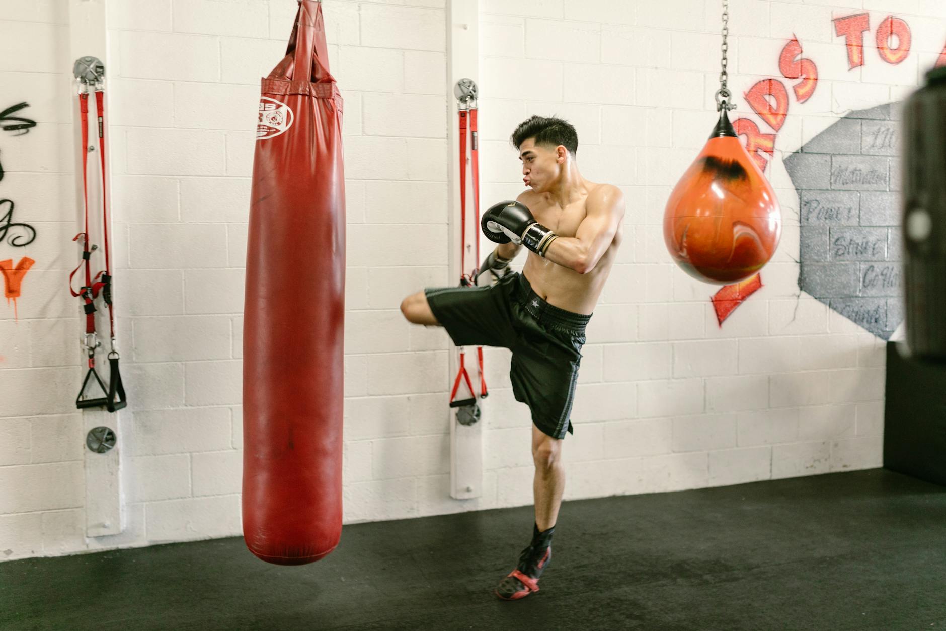 Fit man practicing kickboxing and strength training at a gym. Energetic workout. - upper body cardio workout