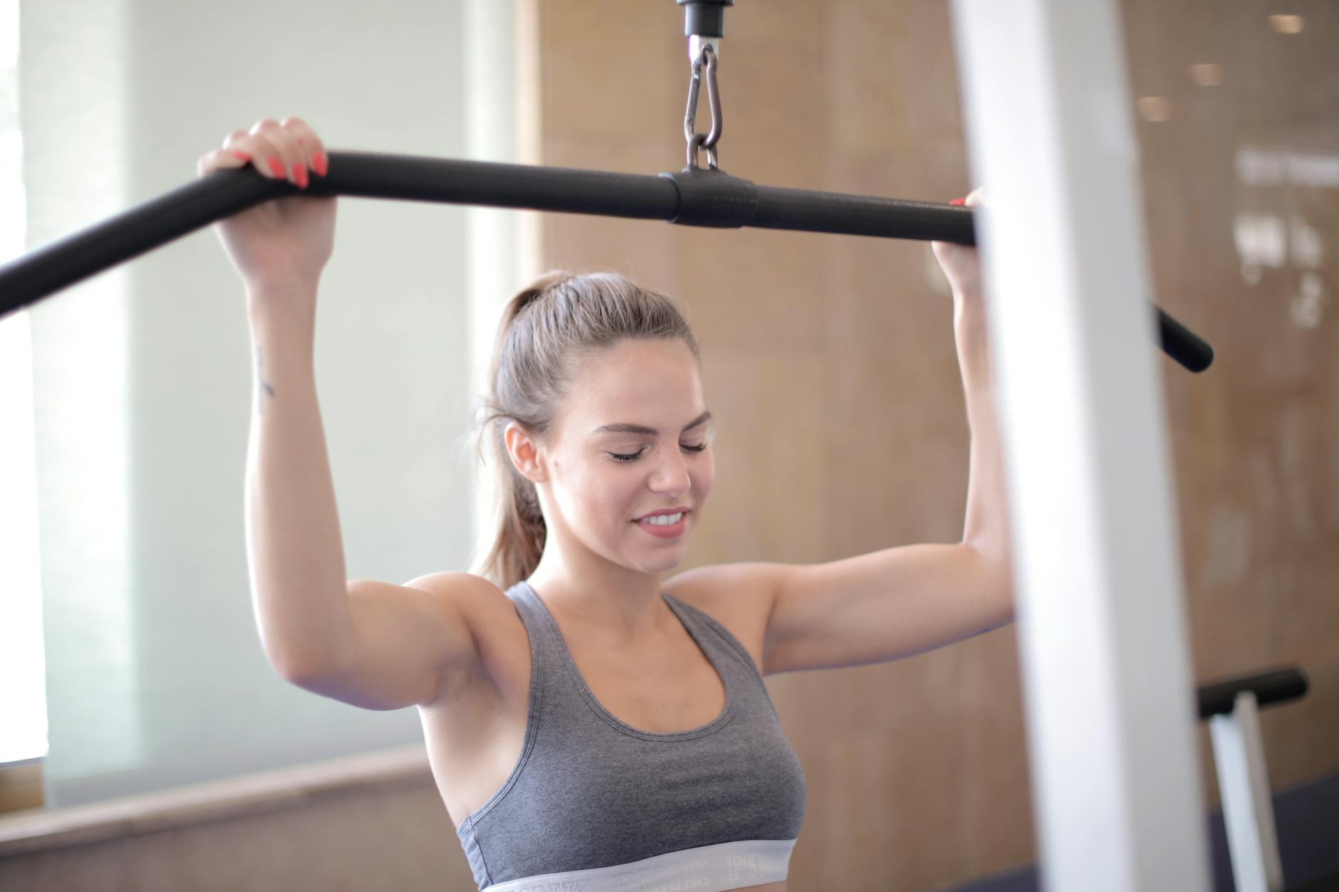 Fit woman exercising on a lat pulldown machine in a gym, focusing on strength training. - upper body cardio workout