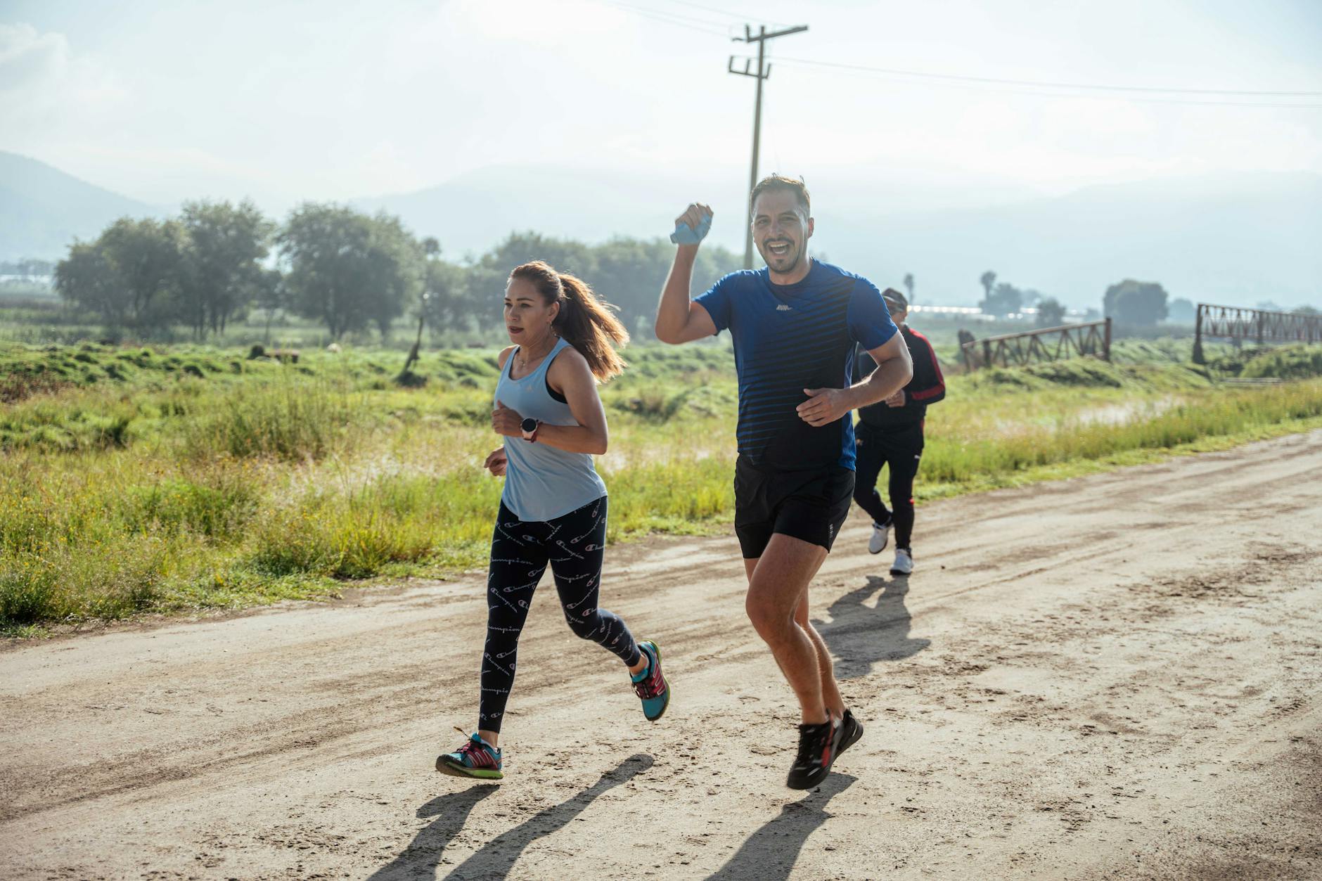 A group of runners enjoys a vibrant morning jog on a rural dirt road. - beginner running plan