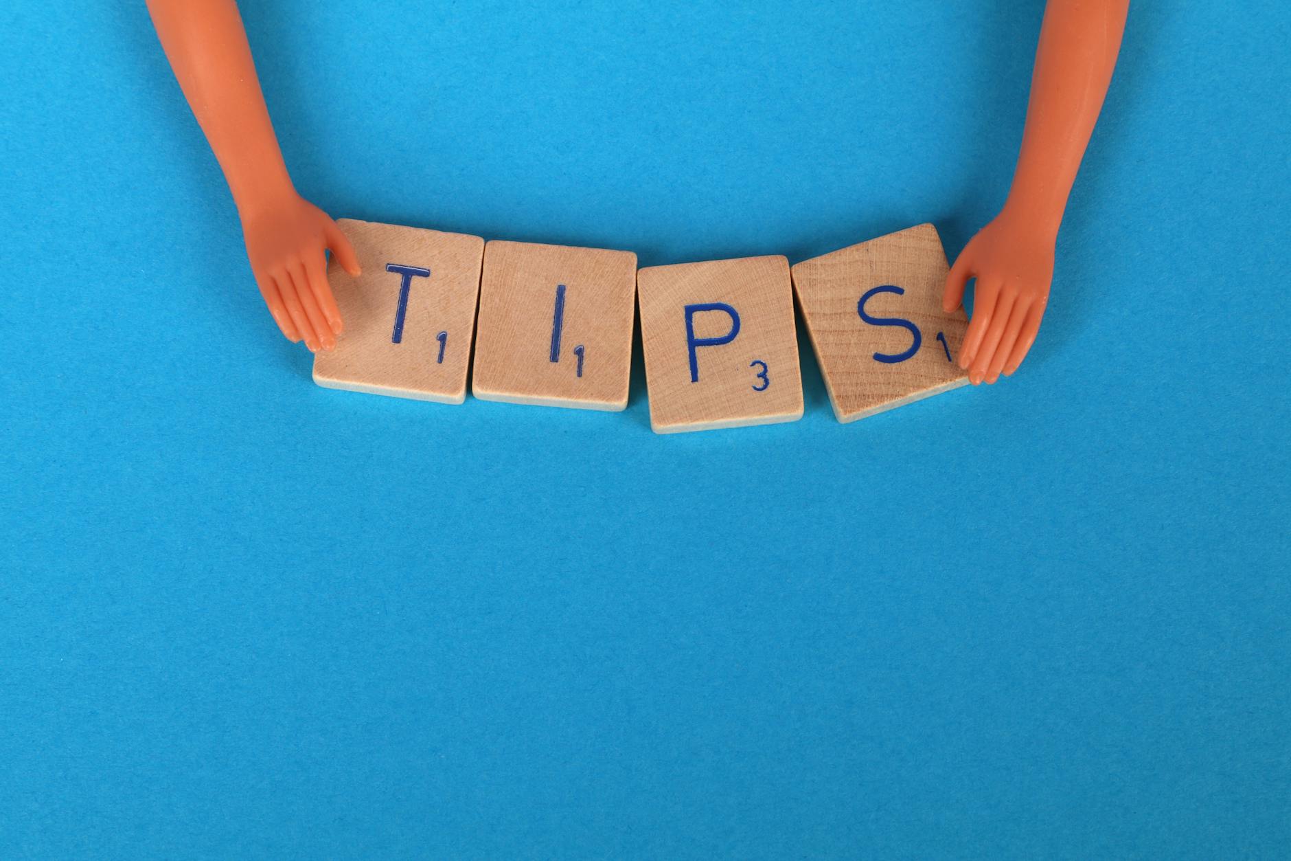 Scrabble tiles spelling 'TIPS' on a blue background, ideal for creative concepts. - beginner running tips