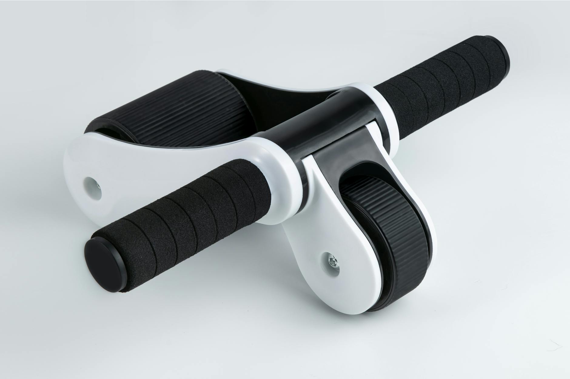 Close-up of a dual wheel ab roller with black handles on a white background, ideal for fitness routines. - best ab workout
