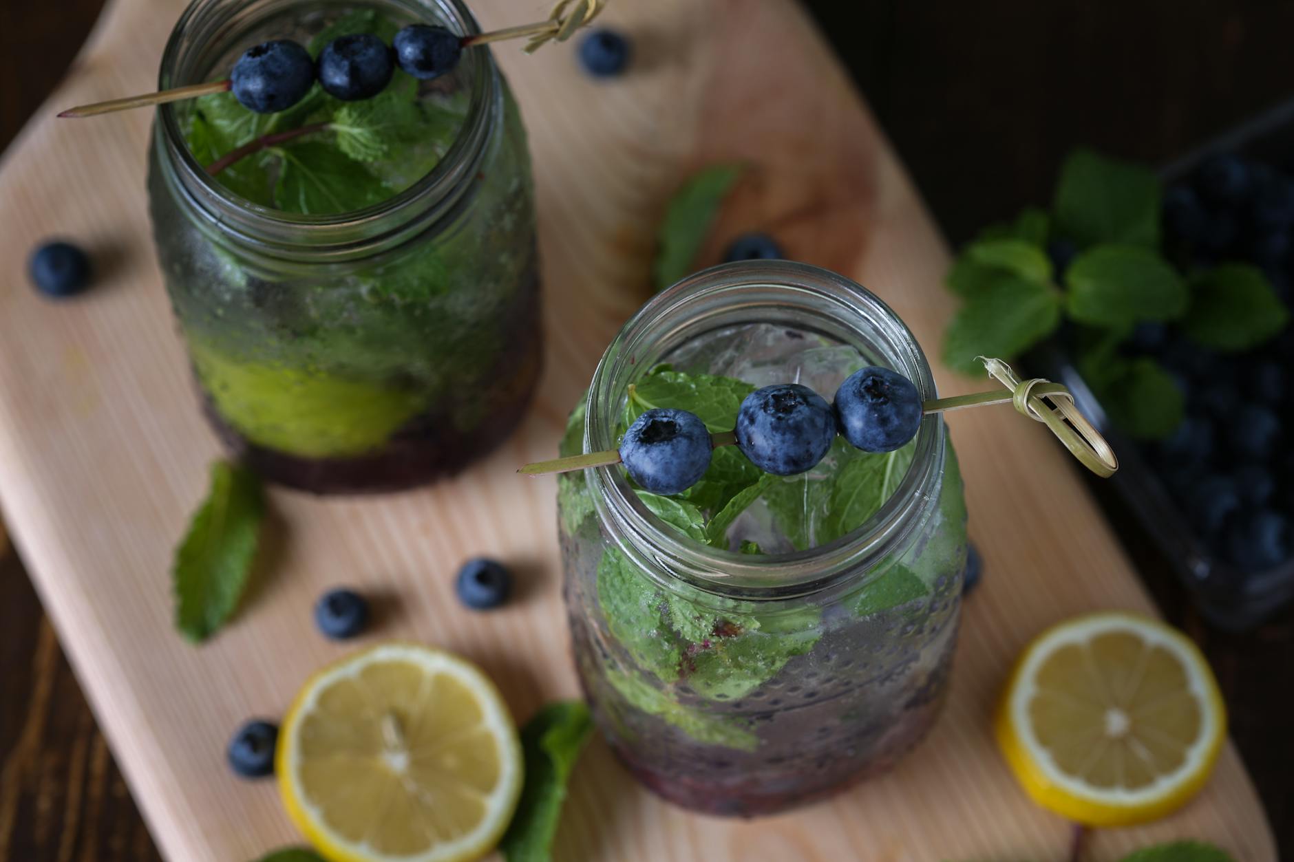 Top-down view of blueberry lemonade in jars with mint and lemon slices, perfect for a refreshing summer drink. - best detox water
