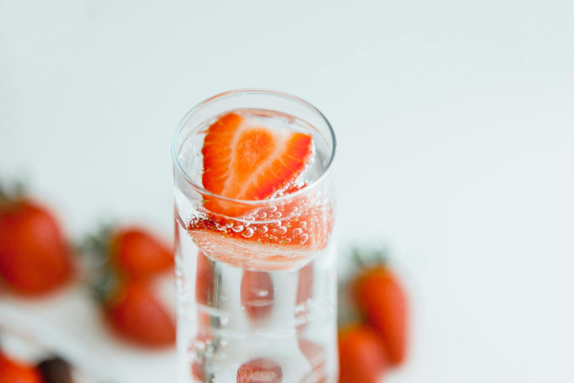 Close-up of strawberries in sparkling water, emphasizing freshness and hydration. - best detox water