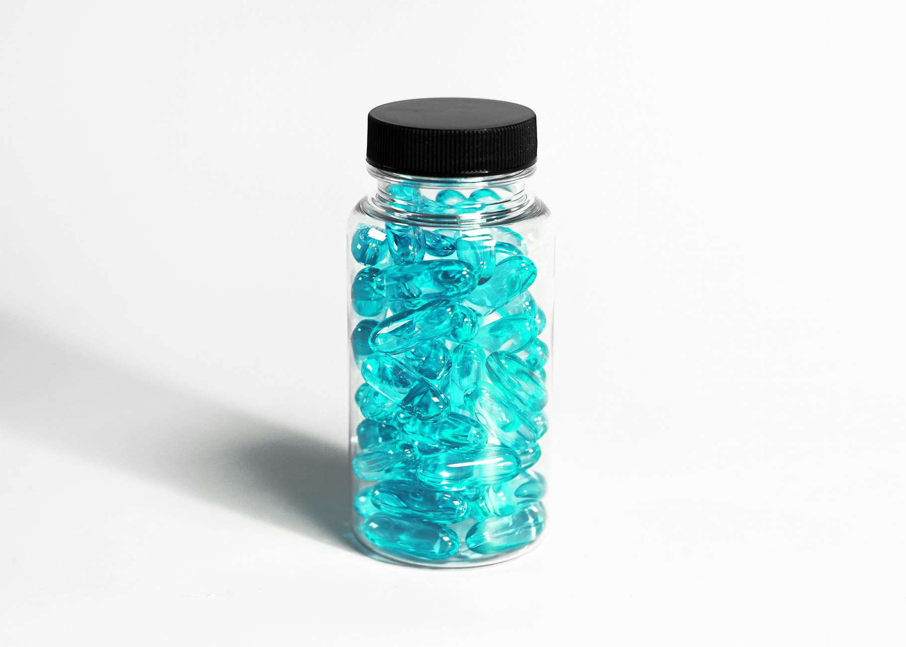 A clear bottle filled with turquoise capsules, showcasing healthcare and nutrition themes. - best magnesium supplement