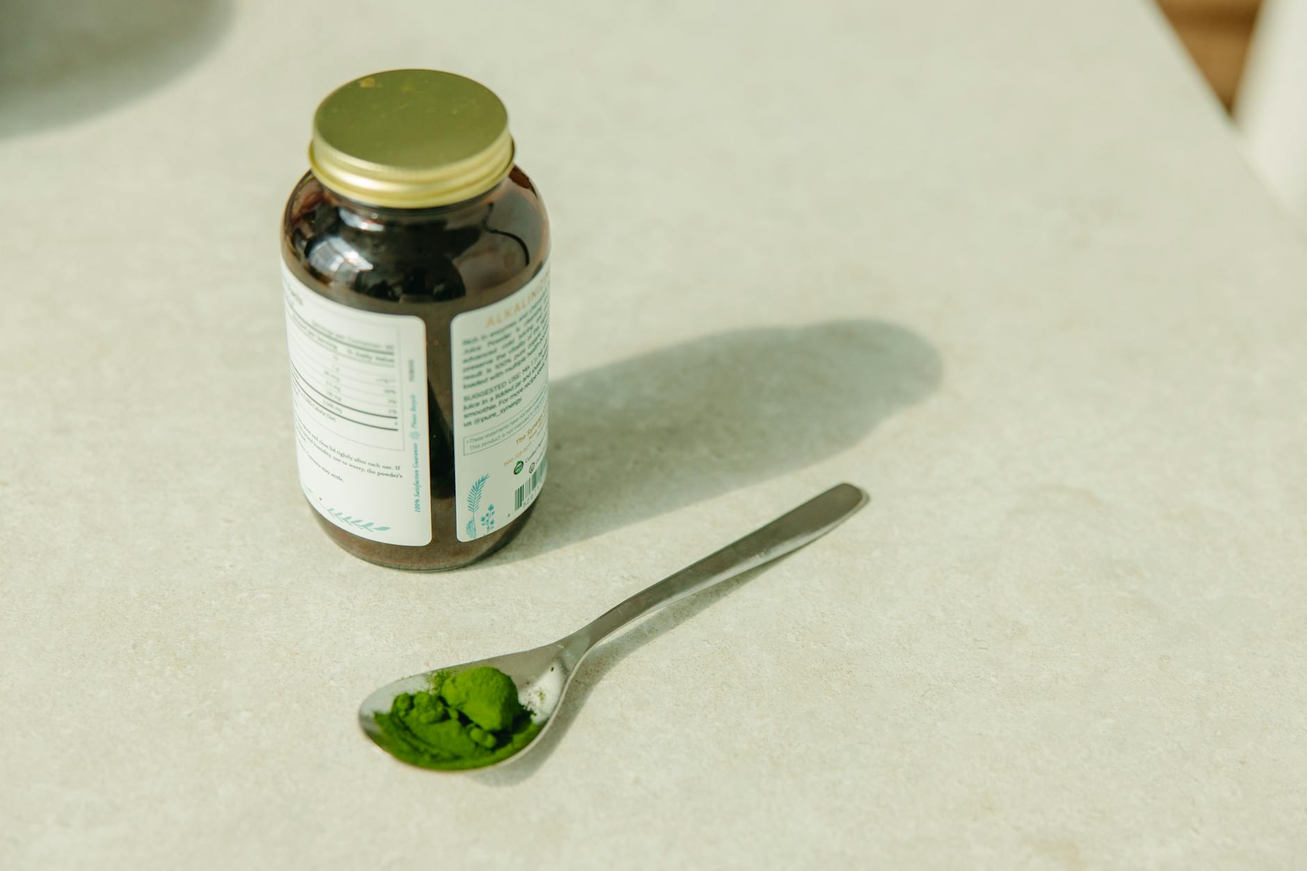 Close-up of a jar and a spoon with green powder, ideal for healthcare and wellness themes. - best magnesium supplement