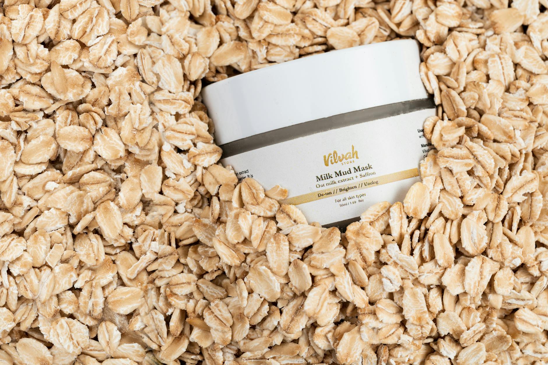 Top view of Vilvah Milk Mud Mask jar surrounded by rolled oats for skincare and wellness. - best organic skincare