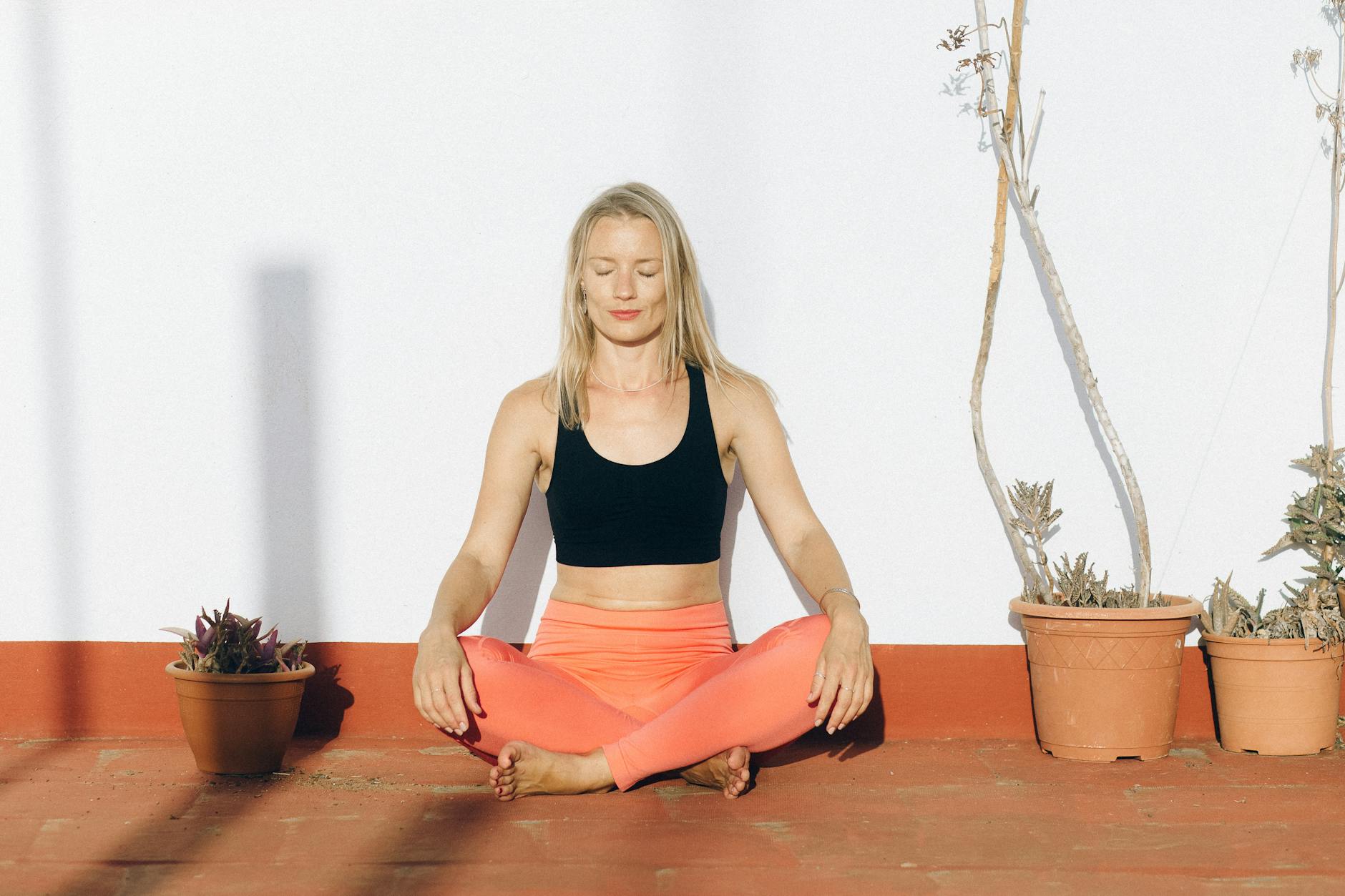 A woman meditating outdoors in activewear, enjoying mindfulness and relaxation. - breathing exercises stress