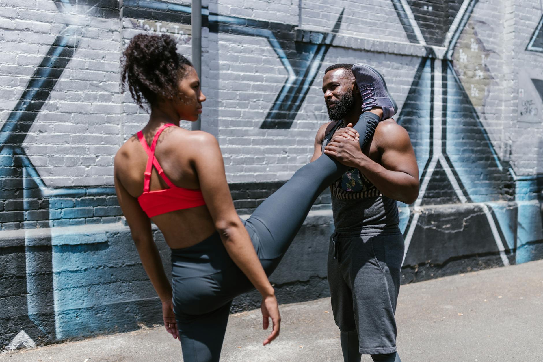 Man and woman in activewear during an outdoor fitness session, showcasing calisthenics. - calisthenics workout routine