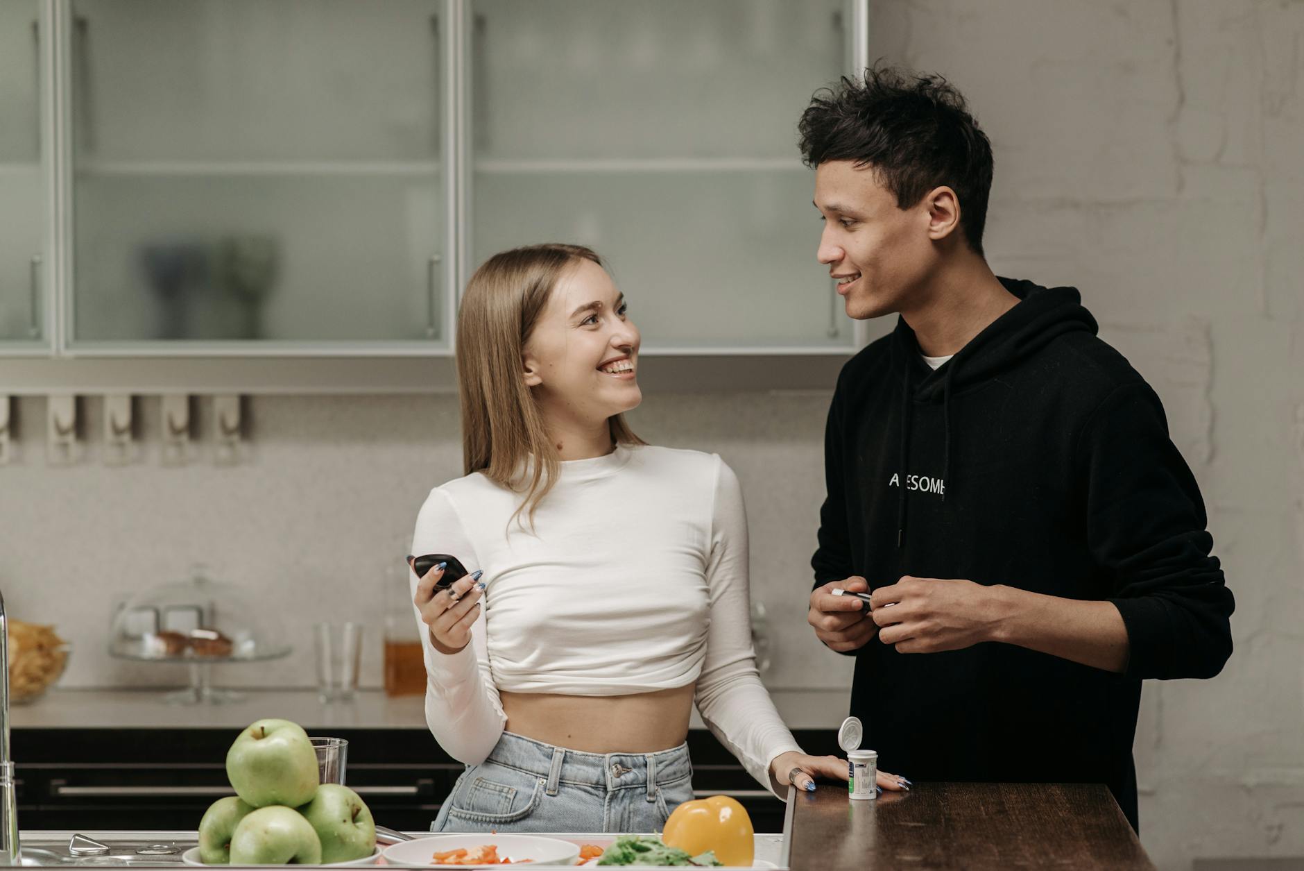 Smiling couple checking blood sugar with glucometer in kitchen. - declutter diet habits