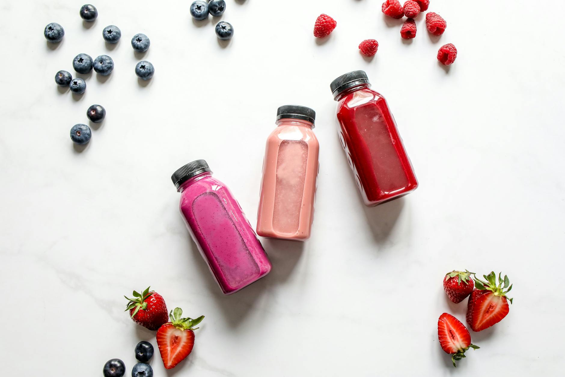 Vibrant array of fruit smoothies with fresh raspberries, strawberries, and blueberries. - diet detox spring