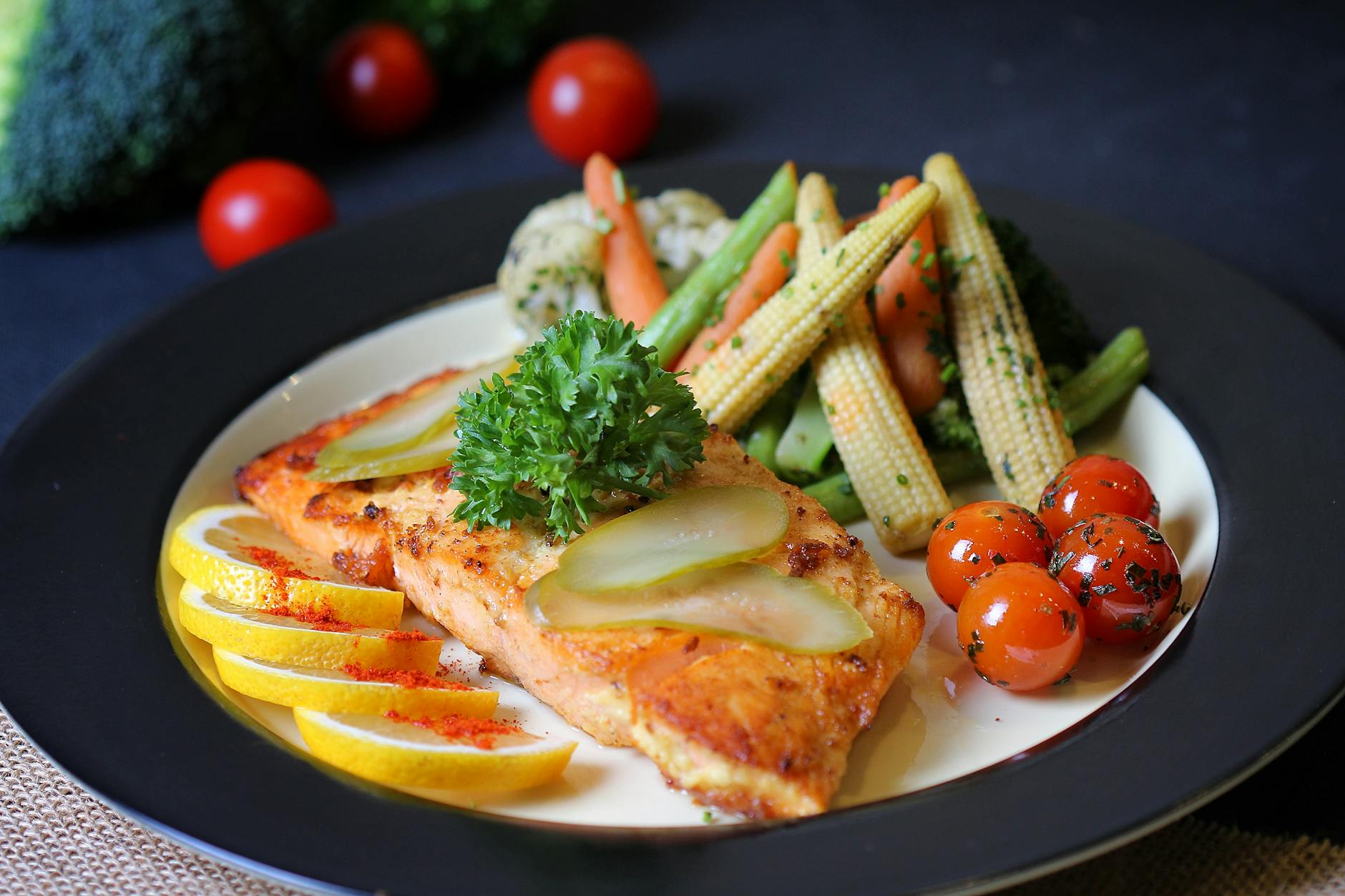 Colorful plate of grilled fish garnished with lemon, pickles, and fresh vegetables. Perfect for healthy meal inspiration. - easy healthy dinners