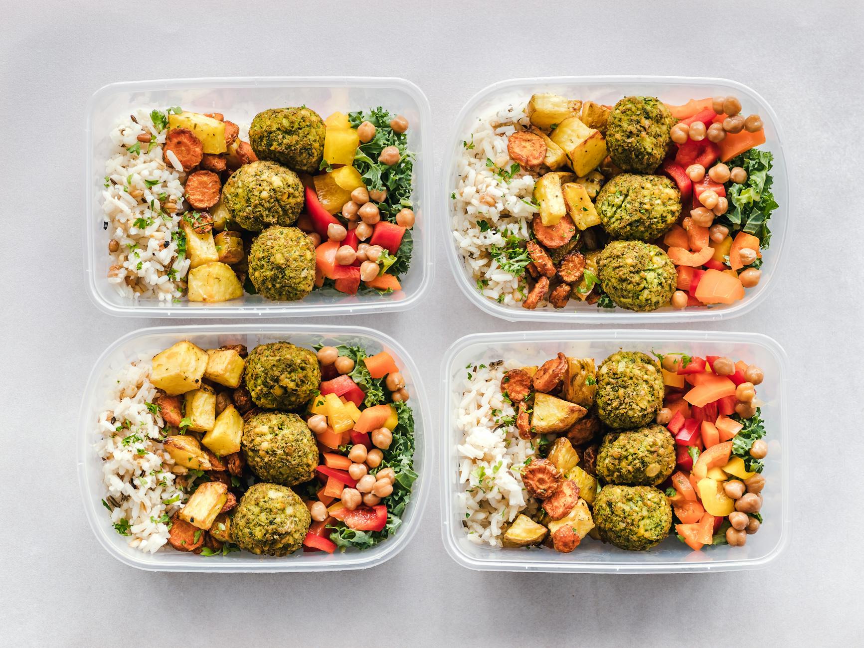 Colorful meal prep containers with falafel, chickpeas, rice, and vegetables for a healthy lifestyle. - easy healthy recipes