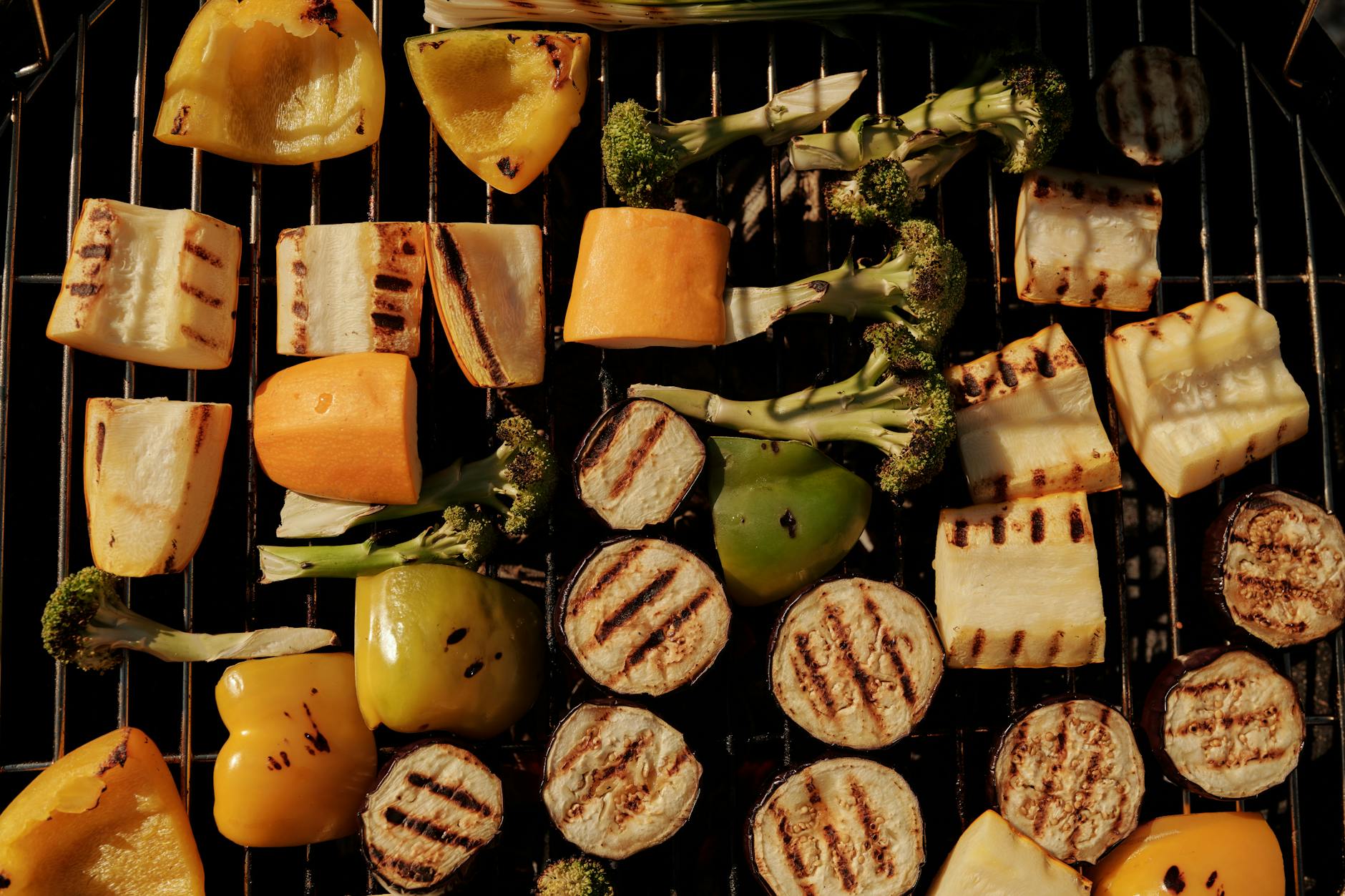 Assorted grilled vegetables including peppers, eggplant, and broccoli on a barbecue grill. - easy healthy recipes