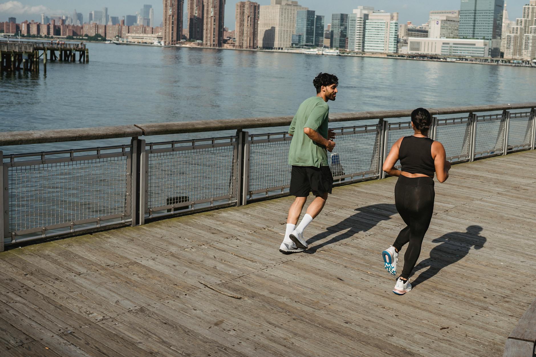 Two adults jogging on a pier, enjoying fitness and a healthy lifestyle by the waterfront. - free running beginners