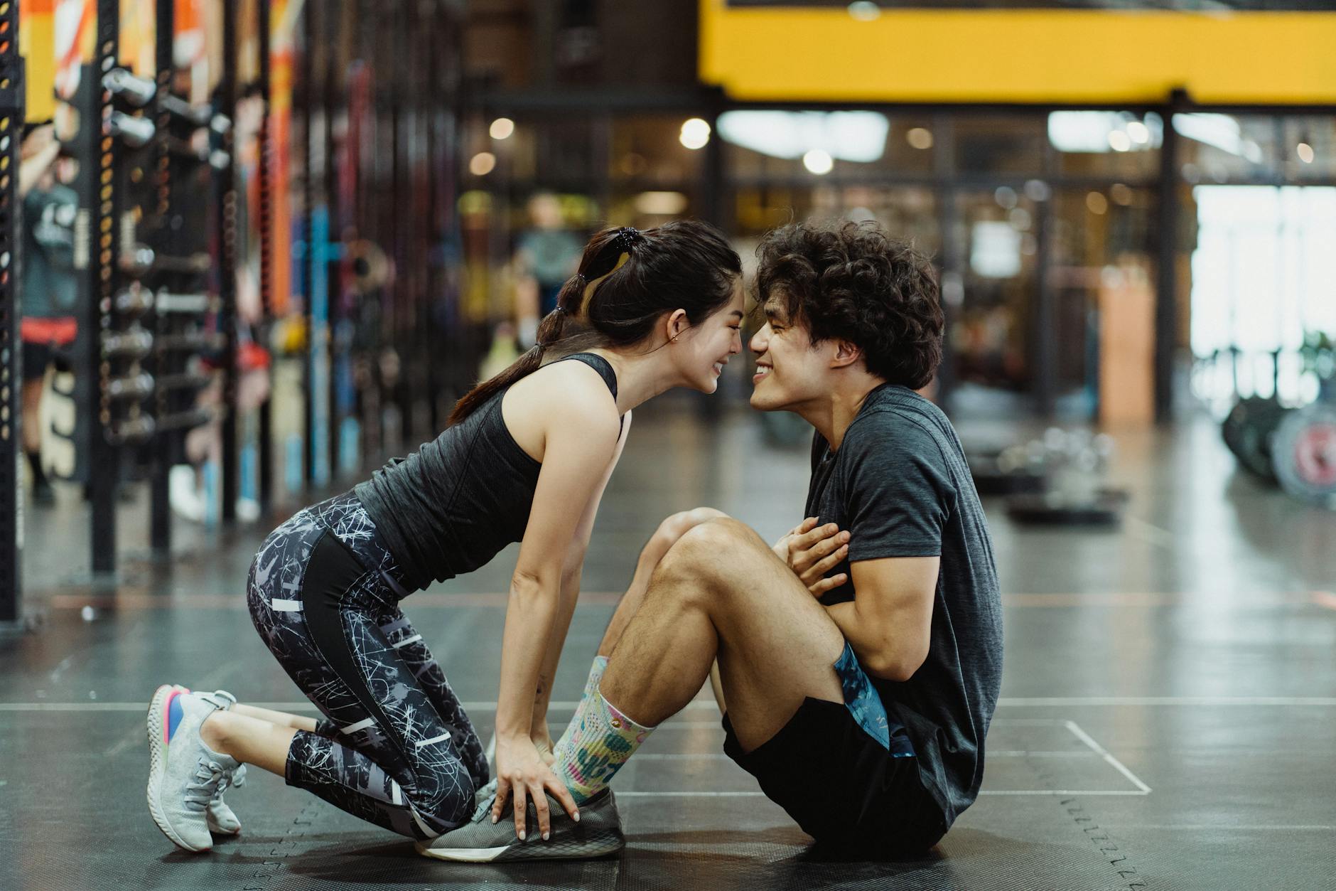 Side view of a happy couple bonding during a workout session in a gym setting. - gym workout plan