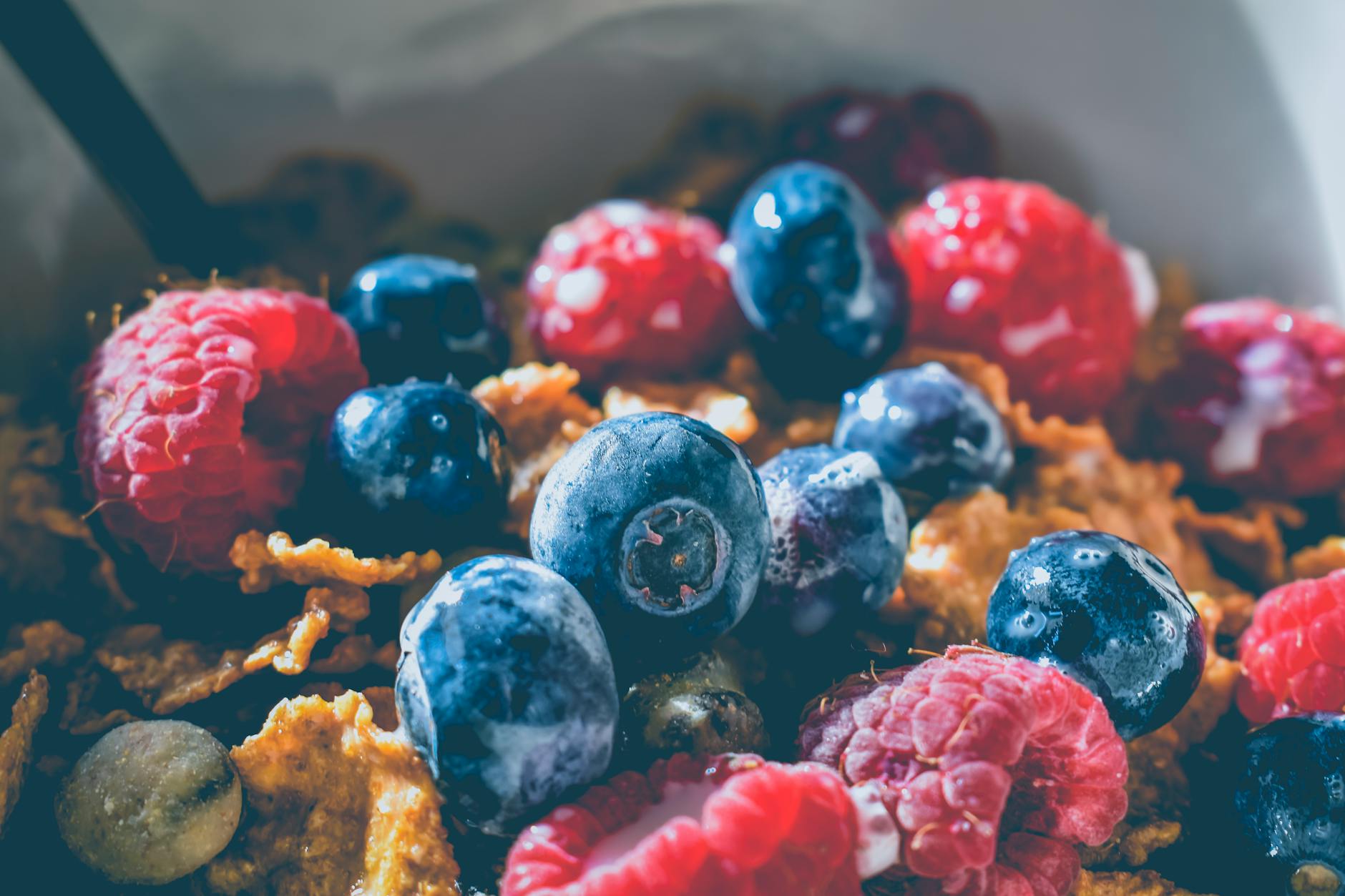 Close-up of a delicious and healthy breakfast with fresh blueberries and raspberries on cereals. - healthy breakfast ideas